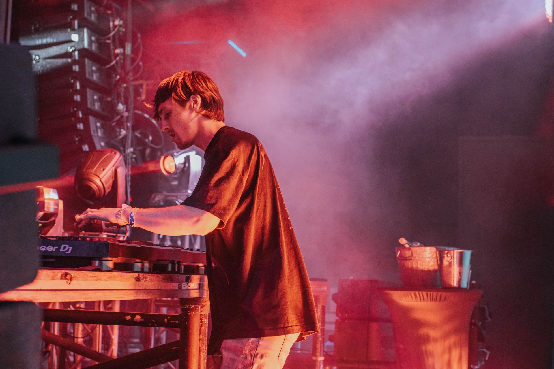 A man is playing a dj set on a stage.