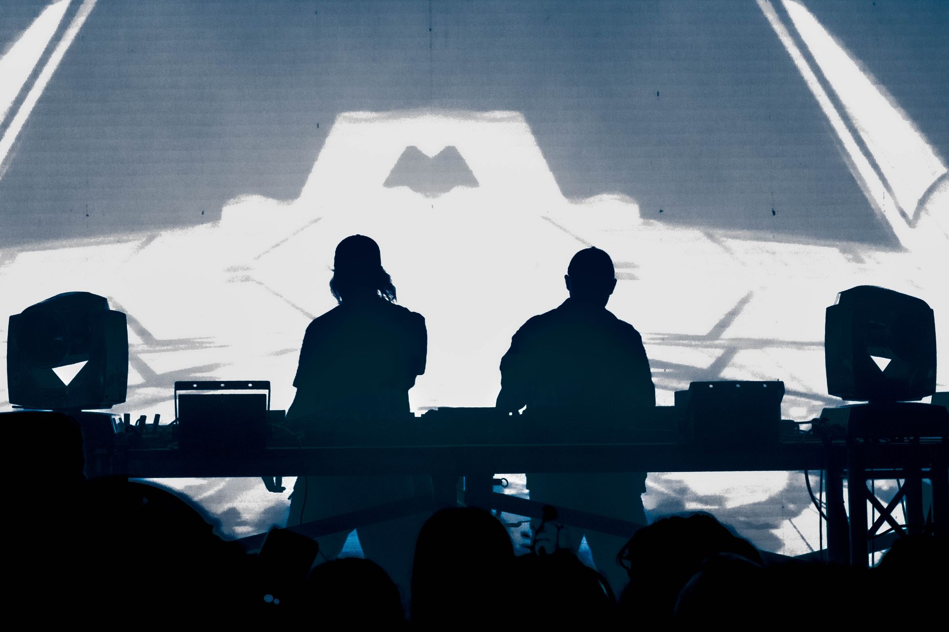 A couple of people sitting at a table in front of a crowd