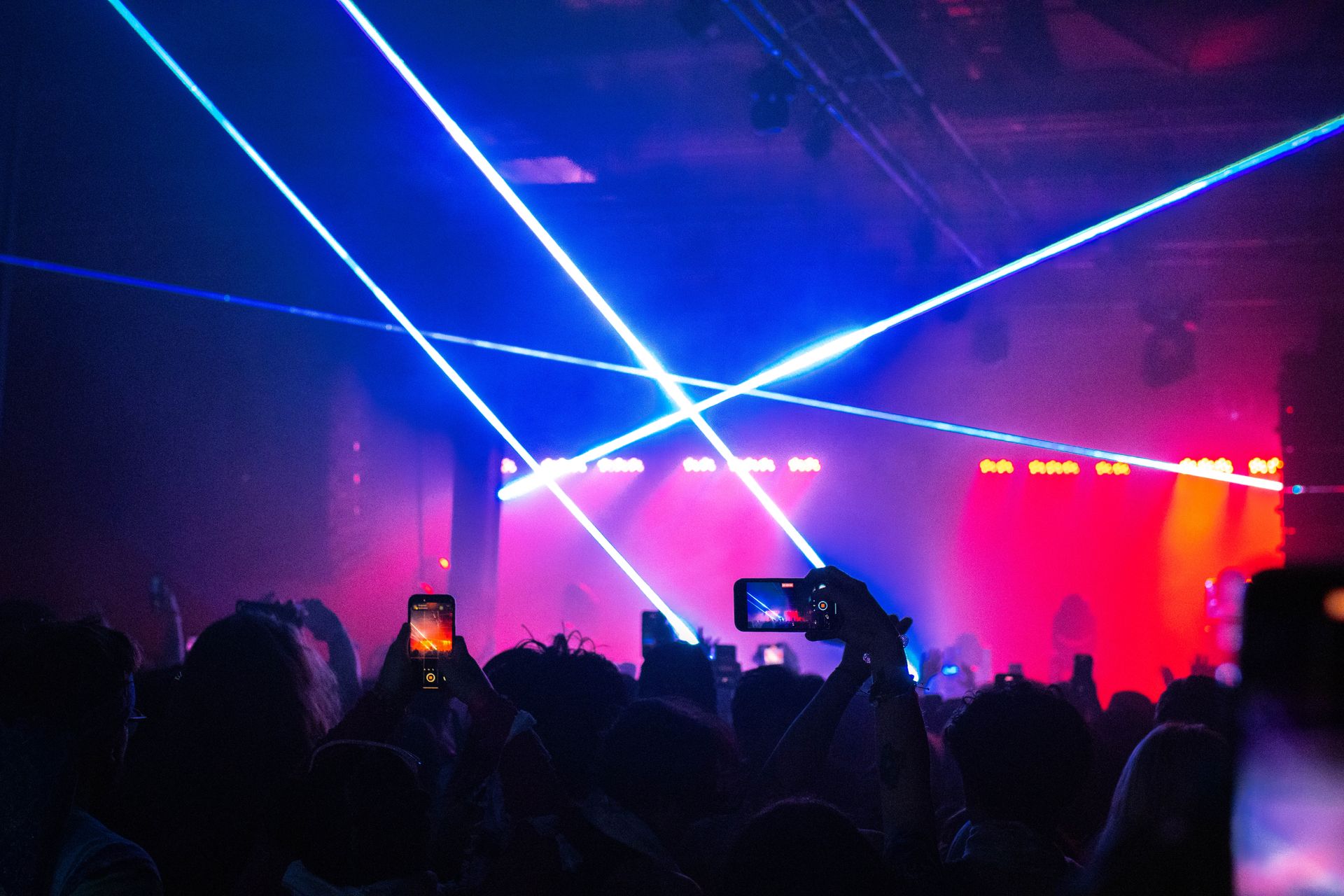 A crowd of people are watching a concert and taking pictures with their phones