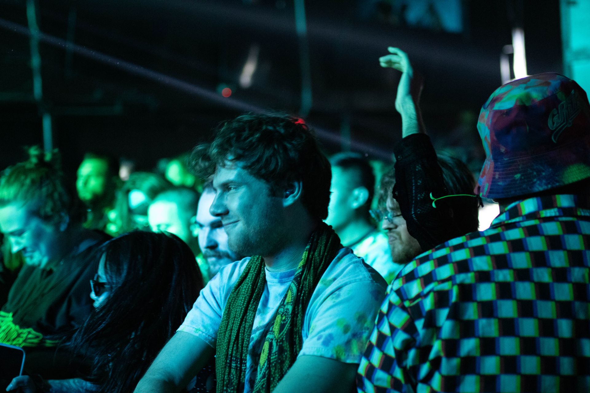 A group of people are sitting in a dark room at a concert.