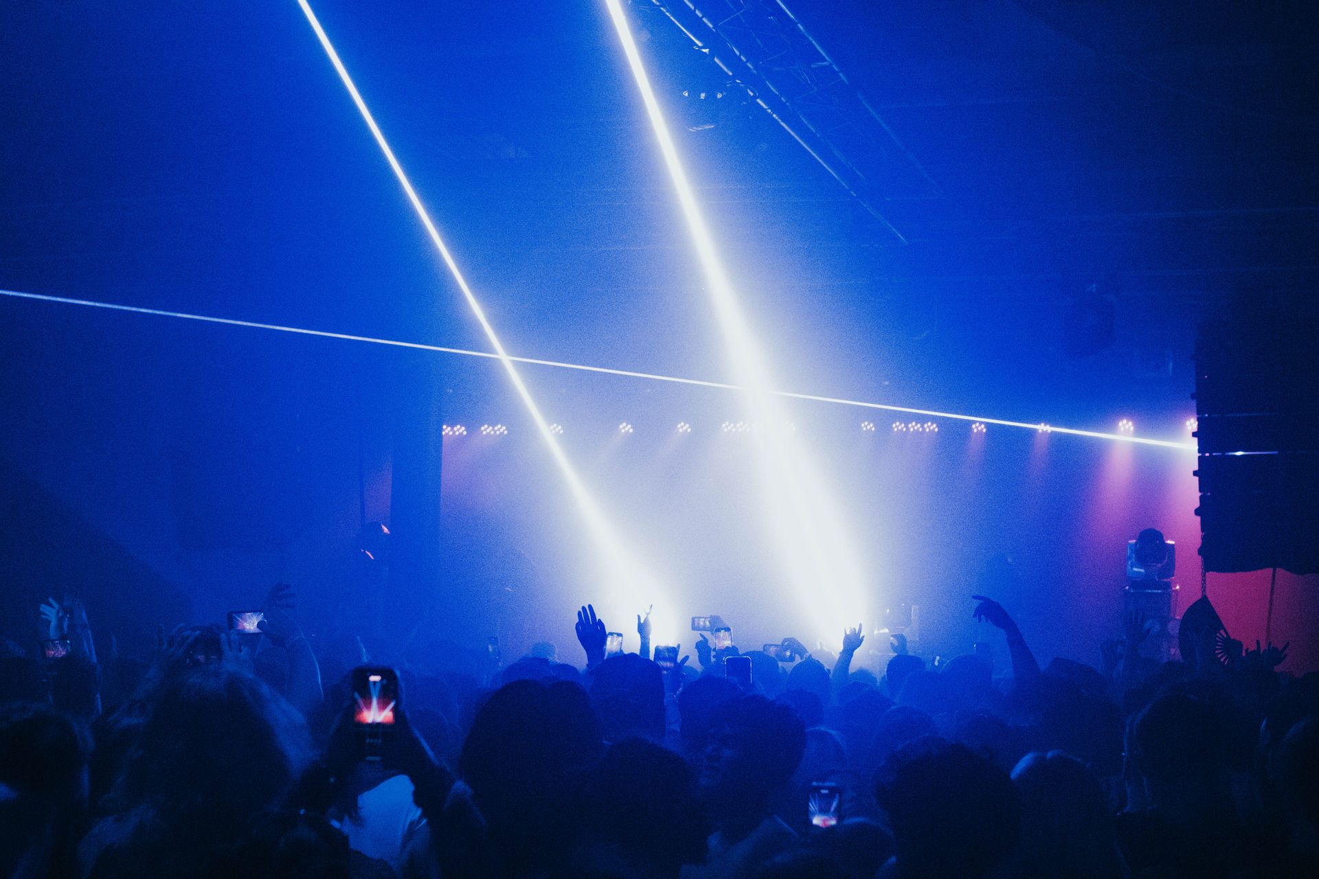 A crowd of people are standing in front of a stage at a concert.