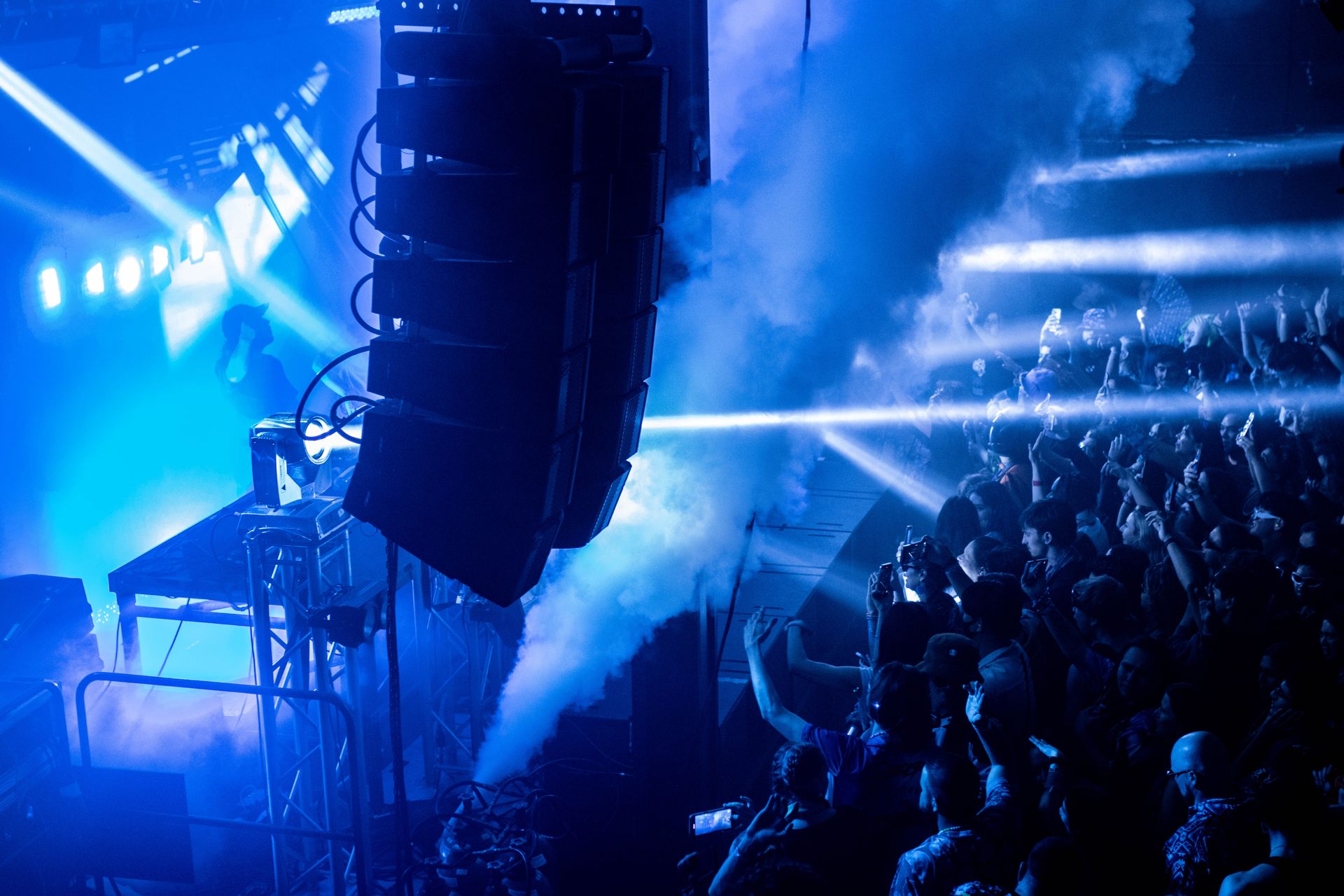 A crowd of people are sitting in front of a stage at a concert.