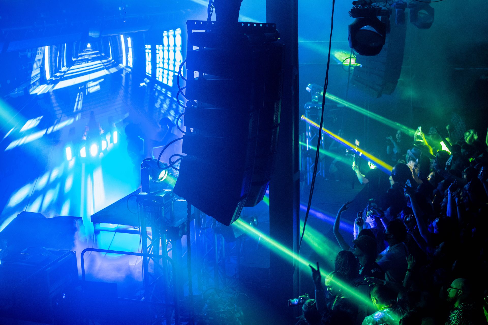 A crowd of people are sitting in front of a stage in a dark room.