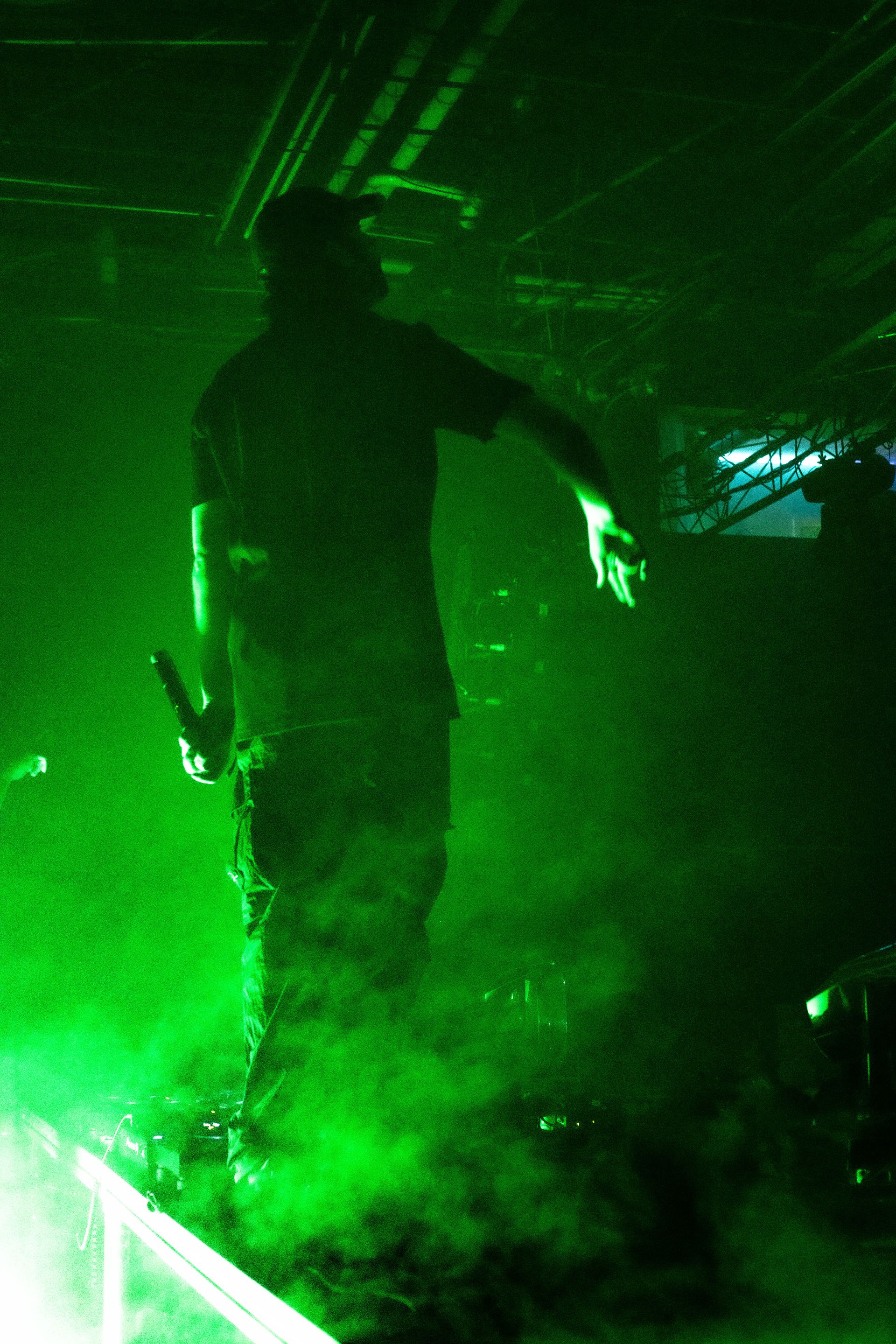 A man is standing in a dark room holding a microphone.