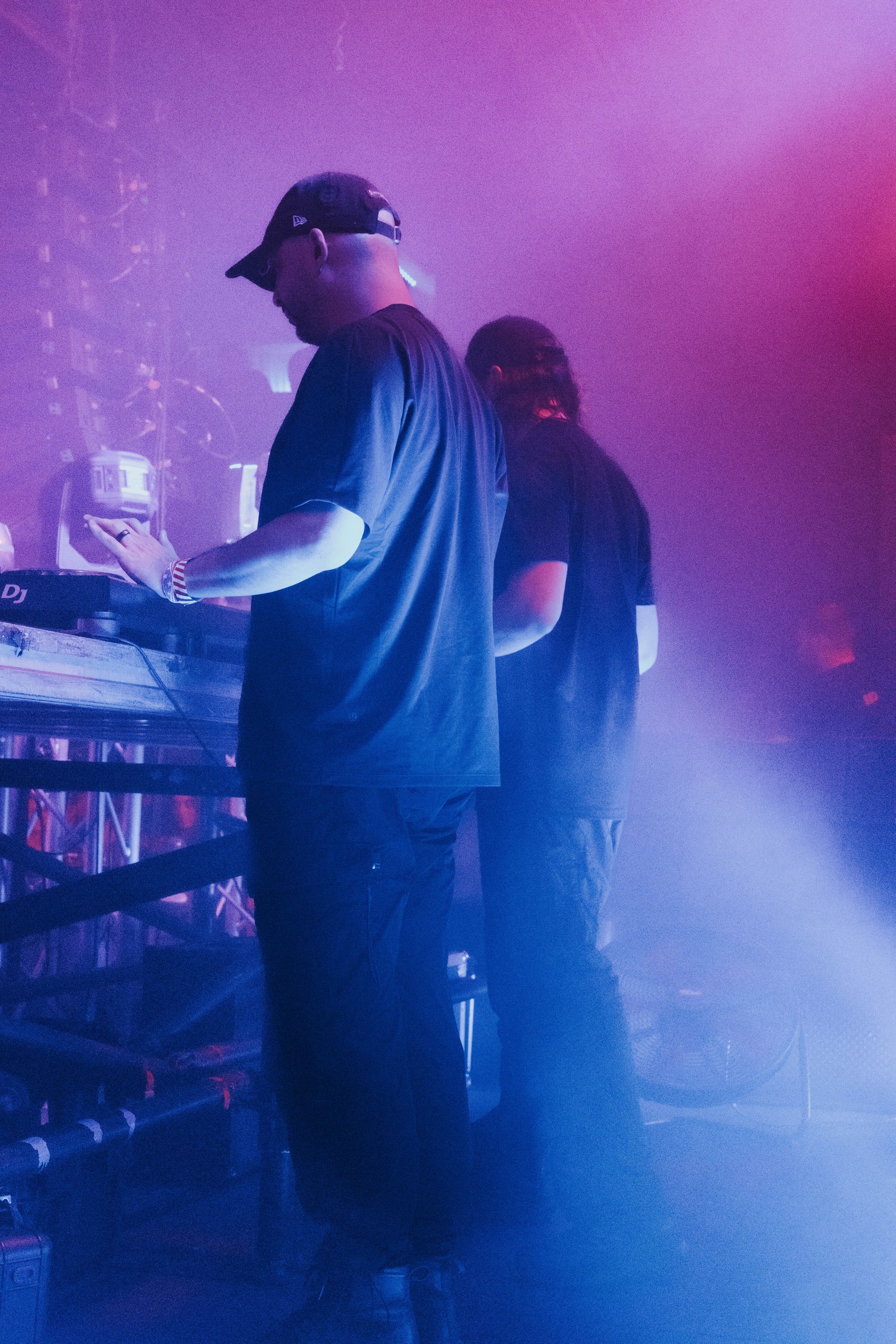A man in a black shirt is playing a keyboard in a dark room.