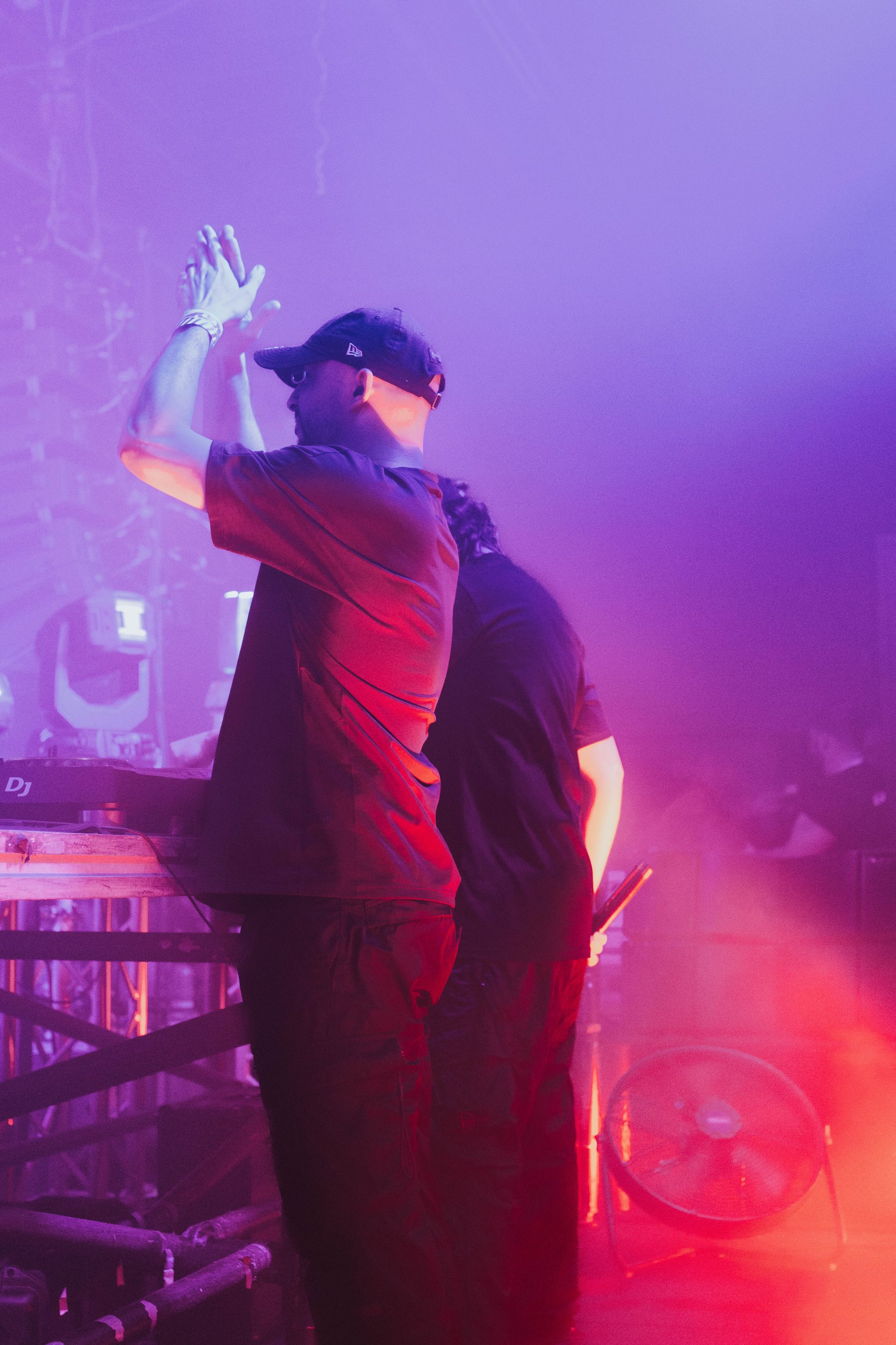 Two men are standing next to each other on a stage in a dark room.