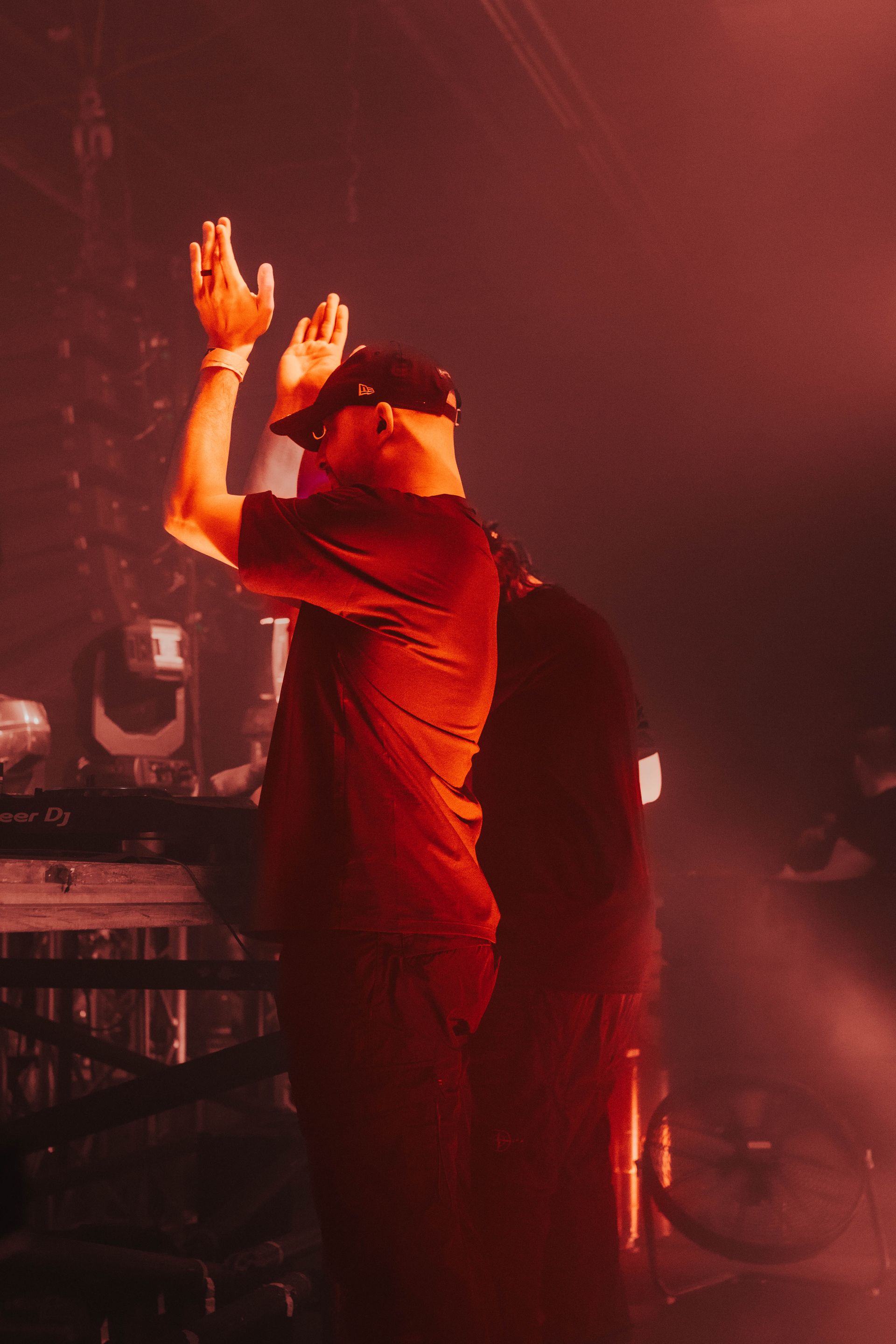 A man is standing on a stage with his hands in the air.
