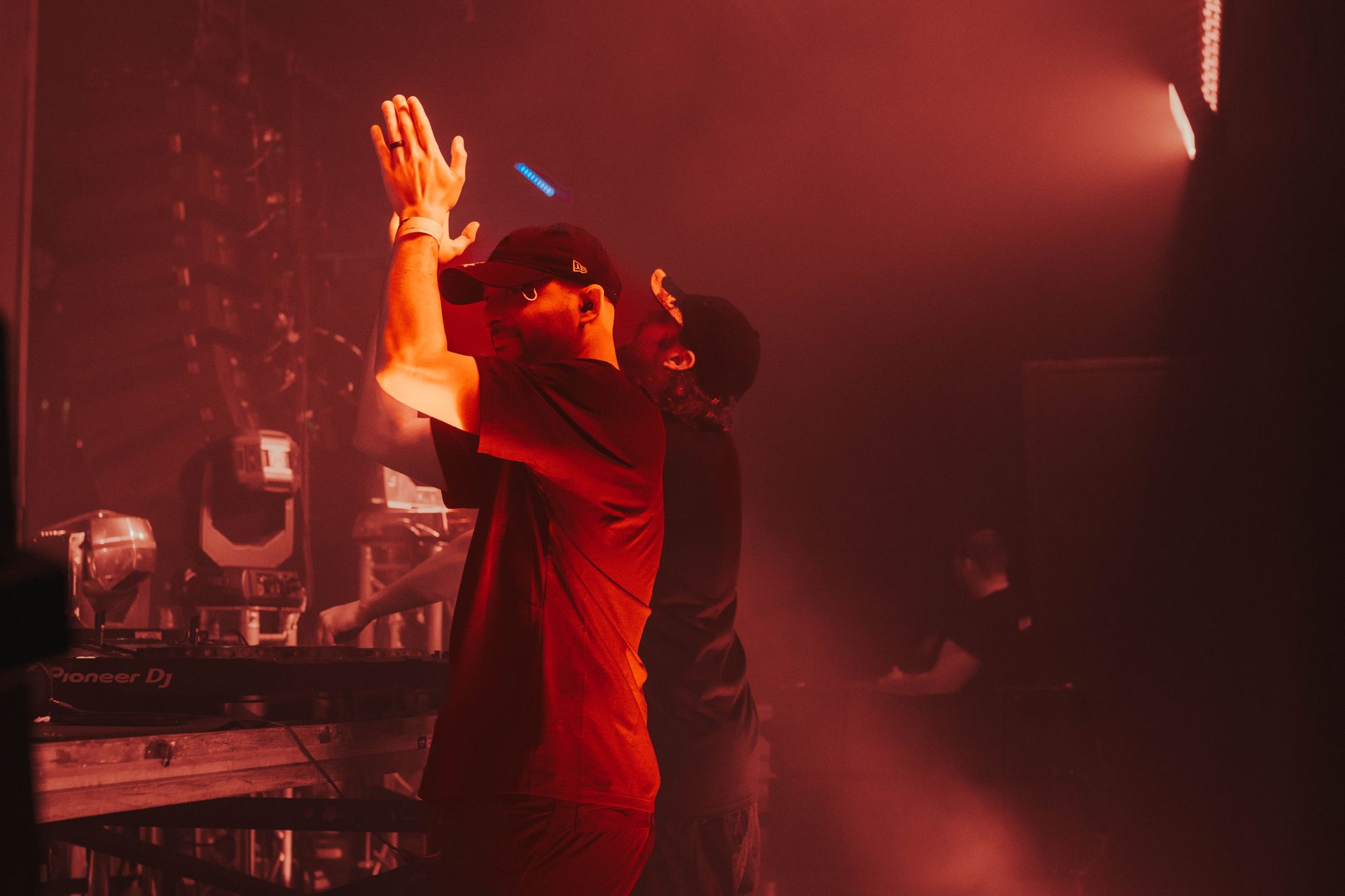 Two men are standing on a stage with their hands in the air.