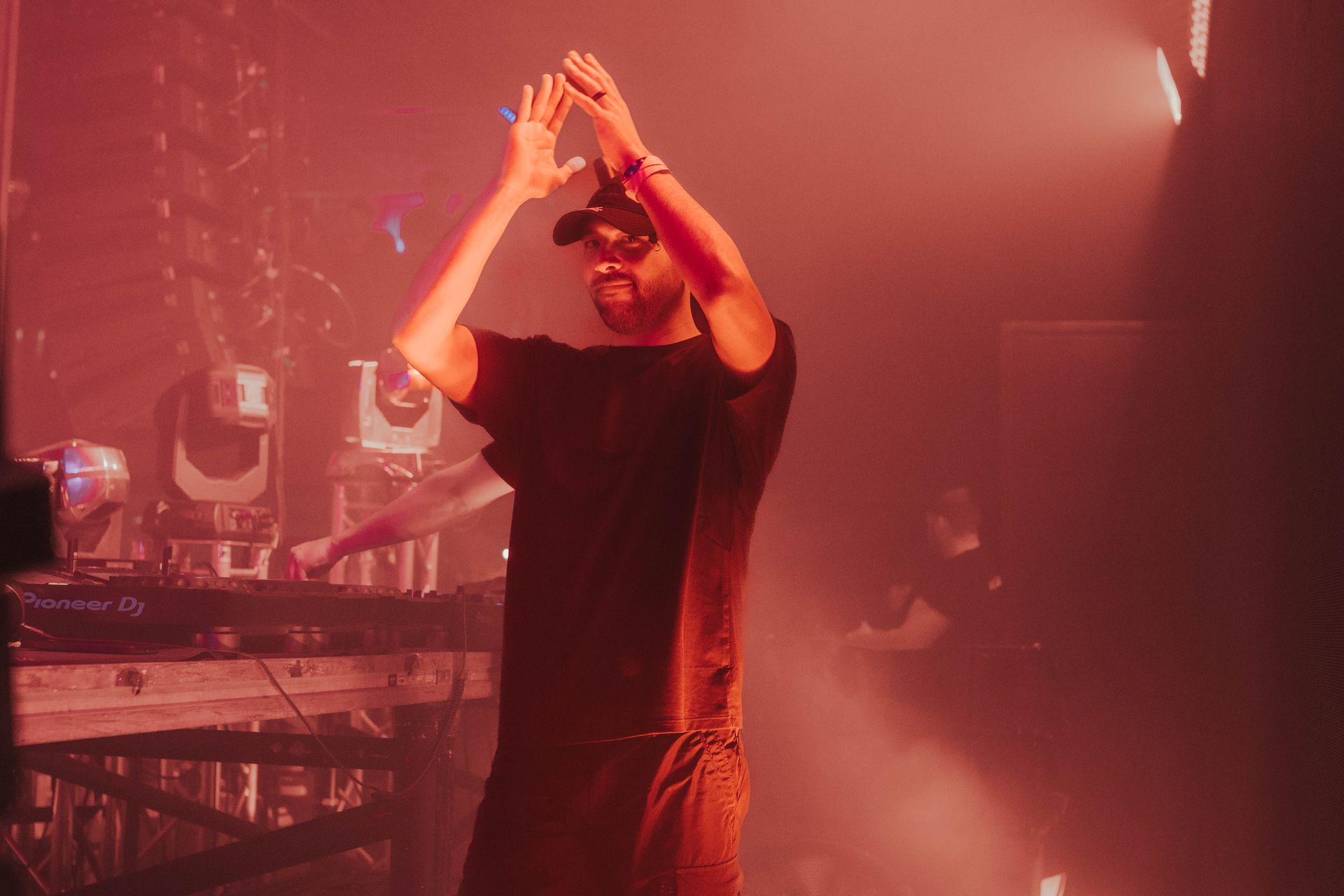 A man is standing on a stage with his hands in the air.