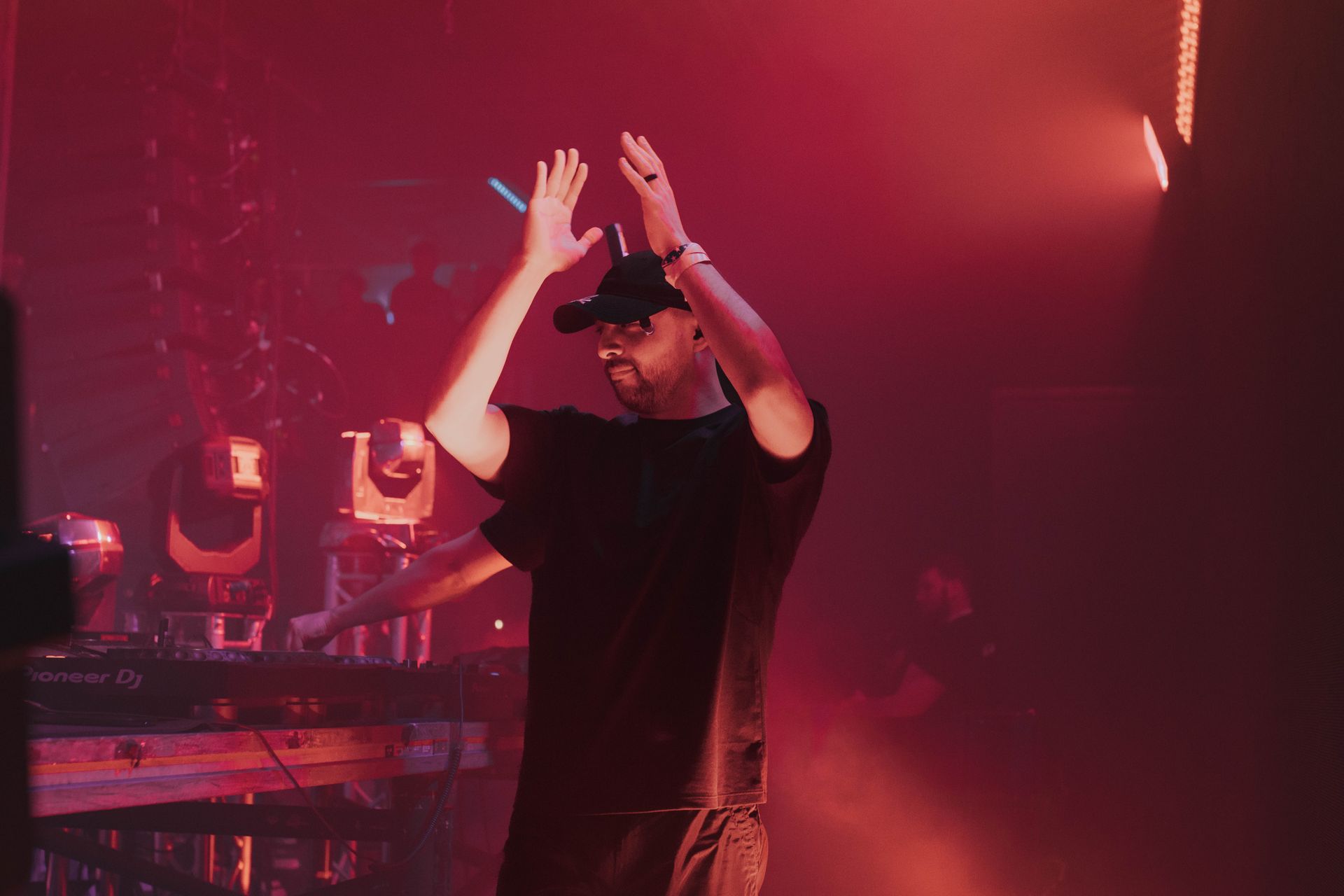 A man is standing on a stage with his hands in the air.