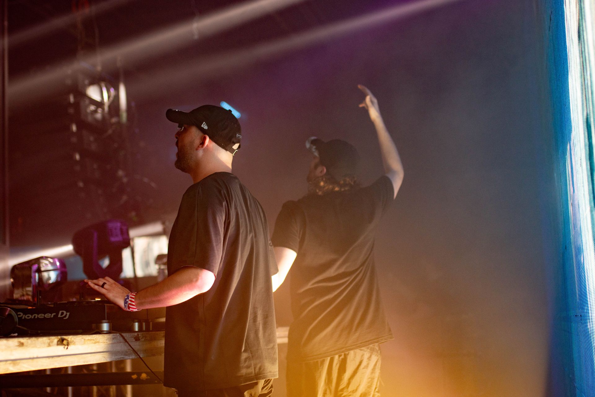 Two men are standing on a stage with their arms in the air.