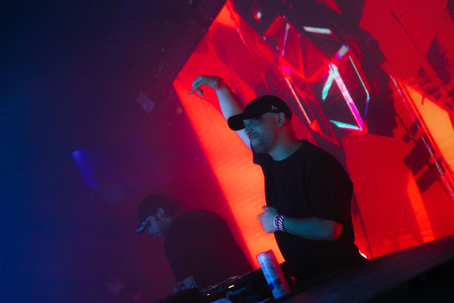 A man is standing in front of a large screen in a dark room.