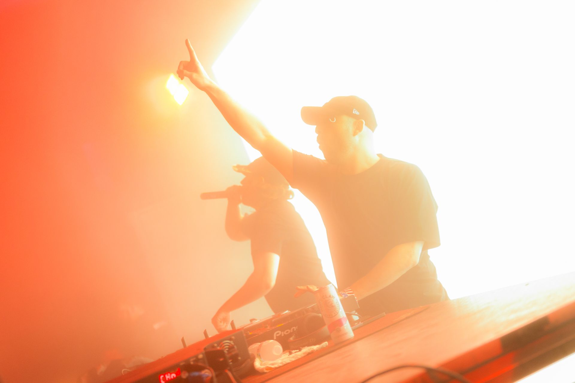 A man is playing a dj set in a dark room.