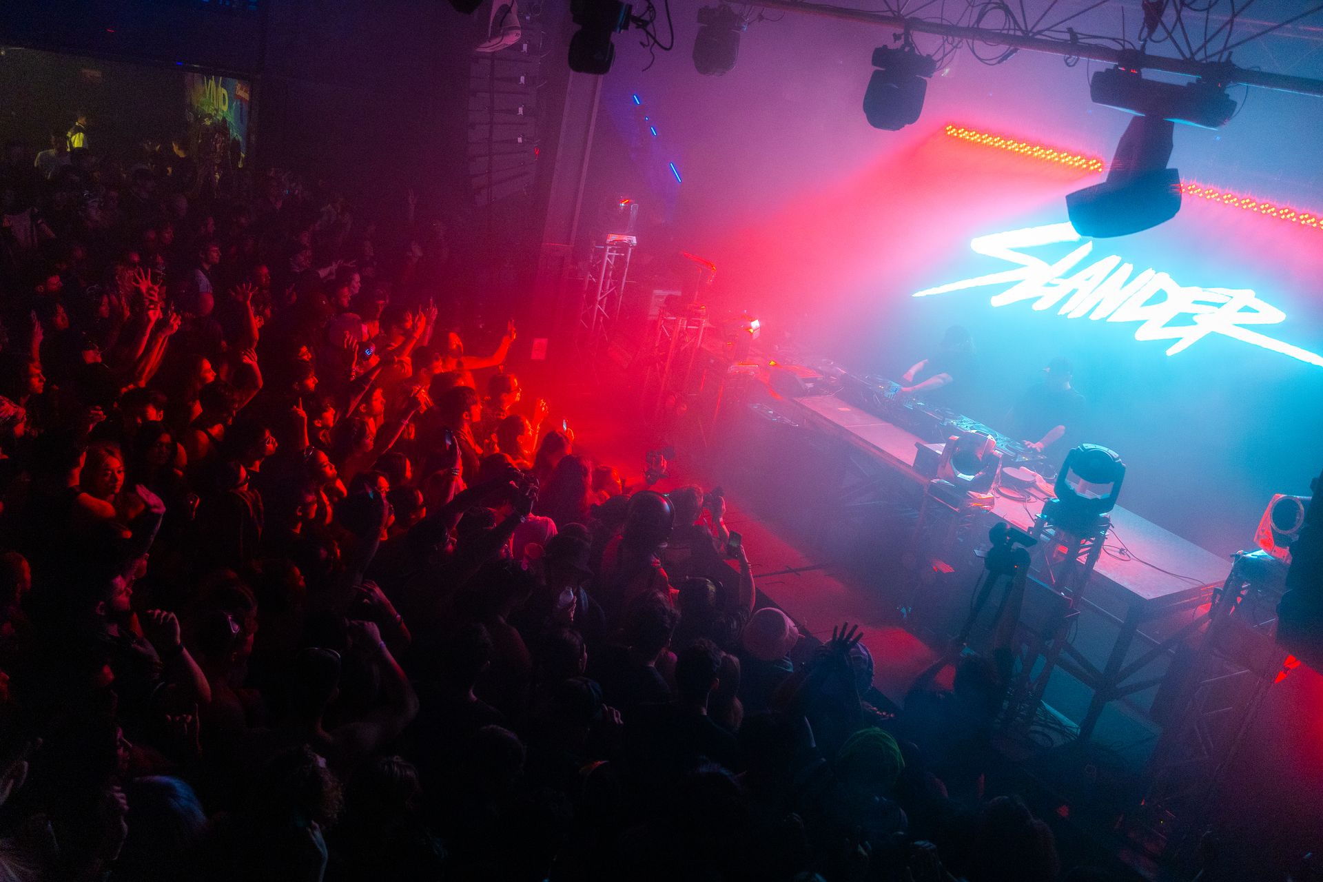 A crowd of people are standing in front of a stage at a concert.