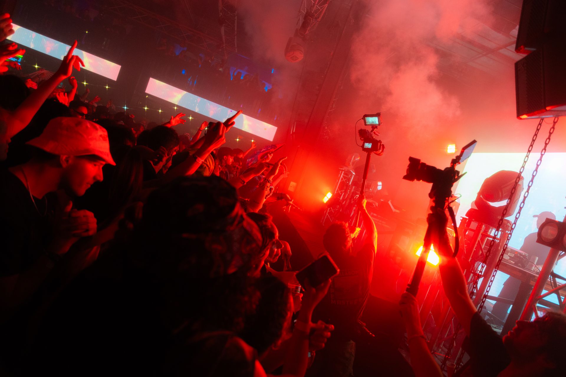 A crowd of people are standing in front of a stage at a concert.