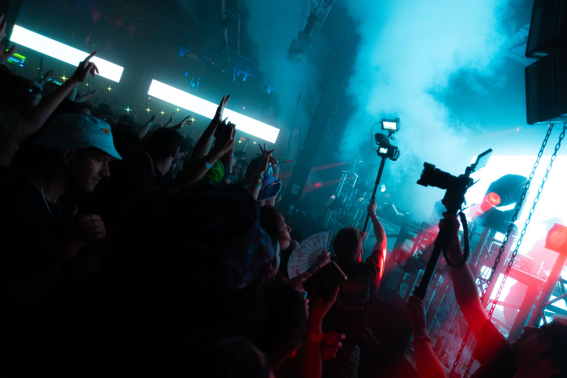 A crowd of people are standing in front of a stage at a concert.