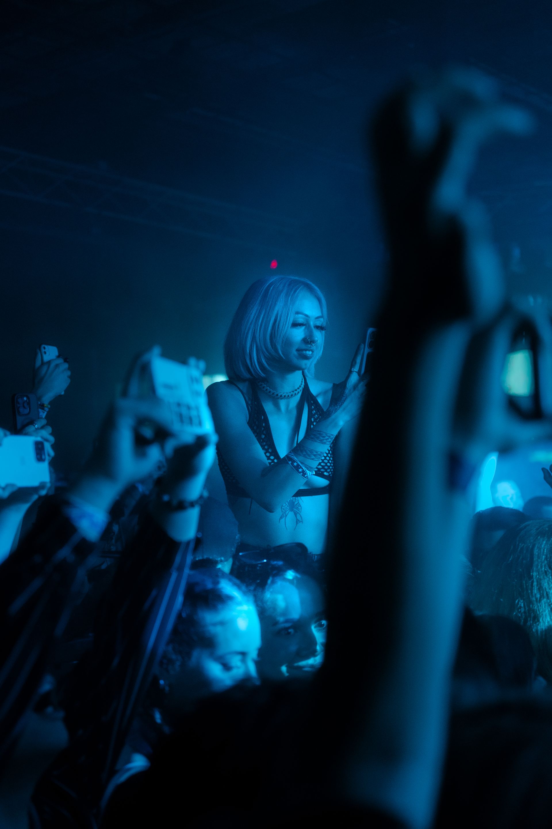 A woman is singing into a microphone in front of a crowd at a concert.