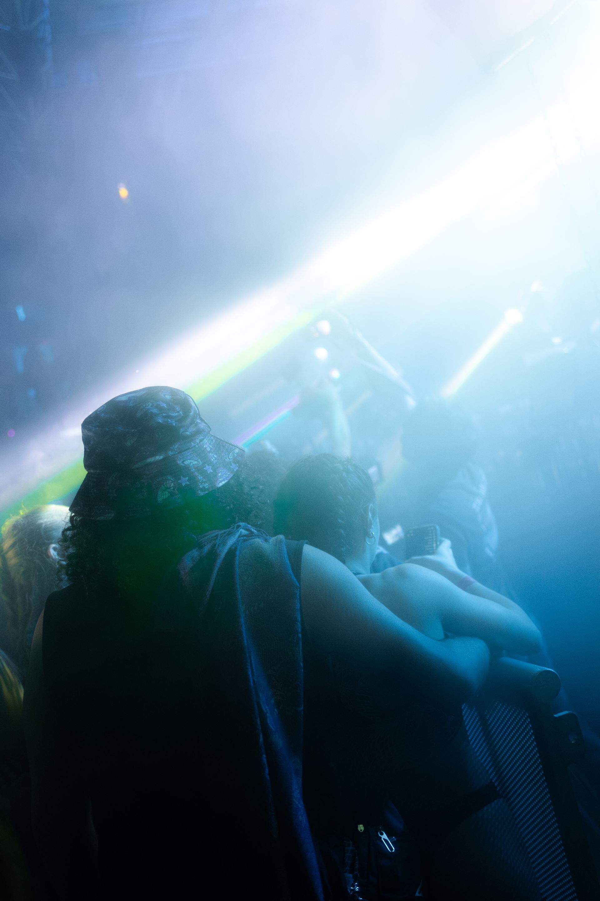 A group of people are sitting in a dark room watching a concert.