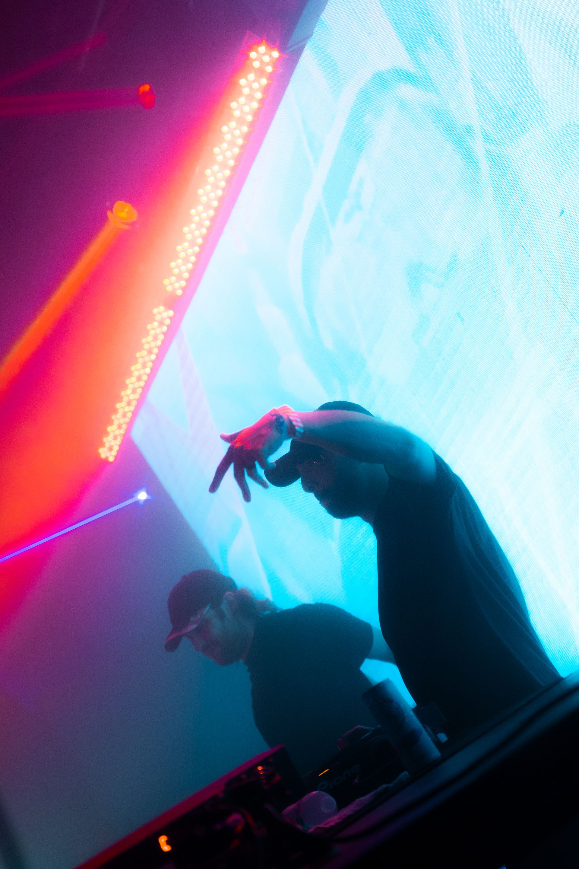 A man is standing in front of a large screen in a dark room.