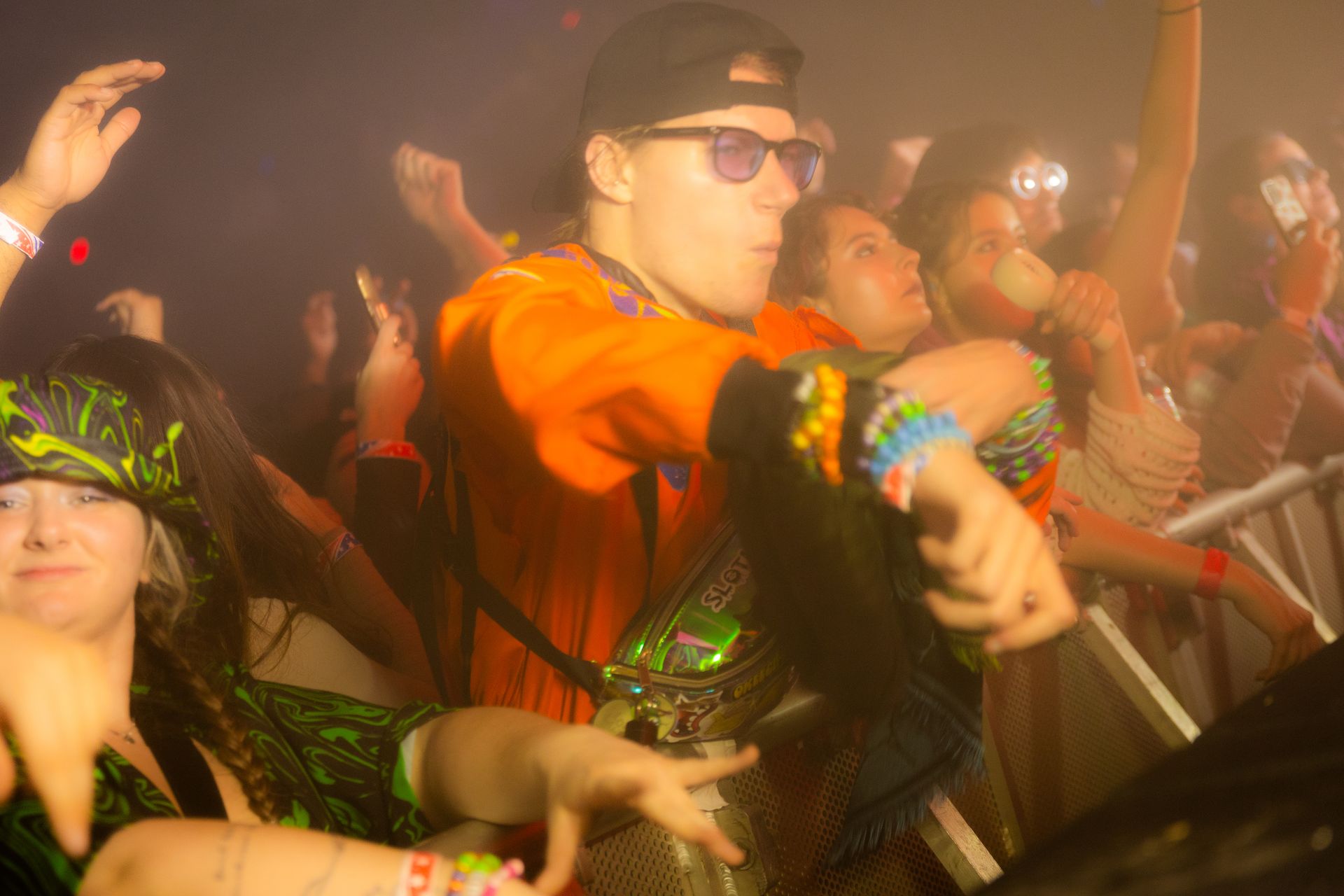 A crowd of people are dancing at a concert.