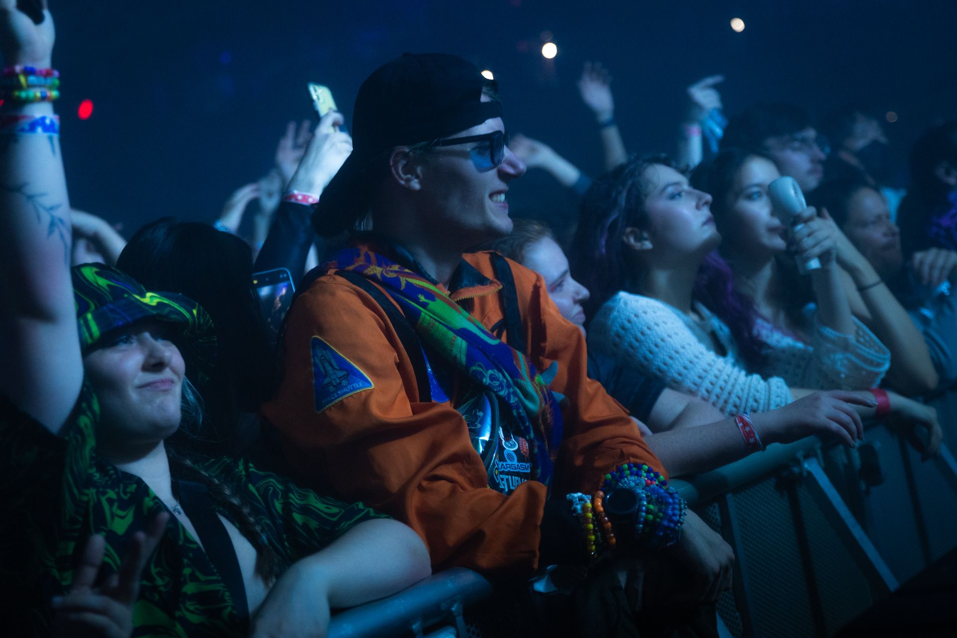 A crowd of people are sitting in a dark room at a concert.