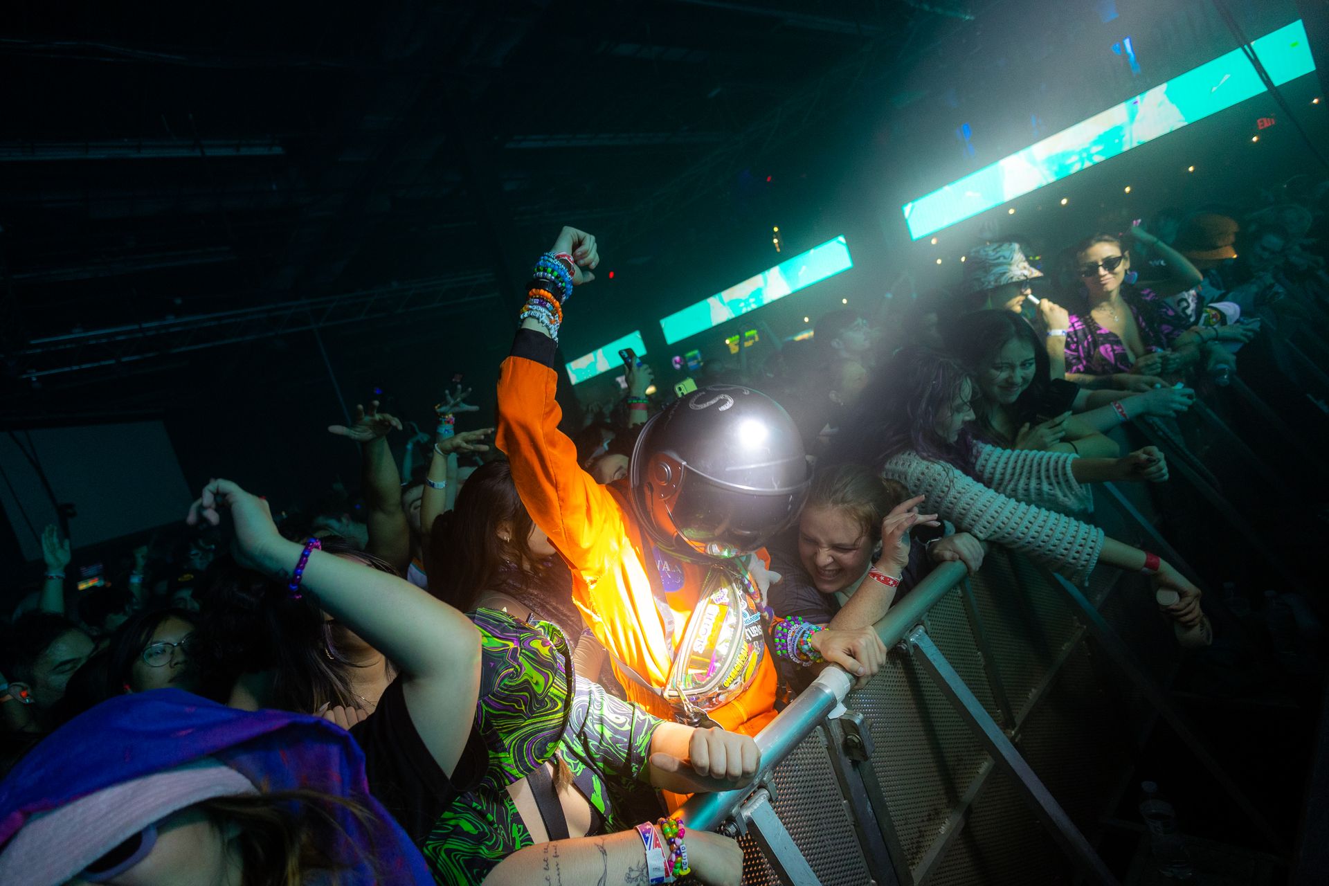 A man is holding a flashlight in his hand in front of a crowd of people at a concert.