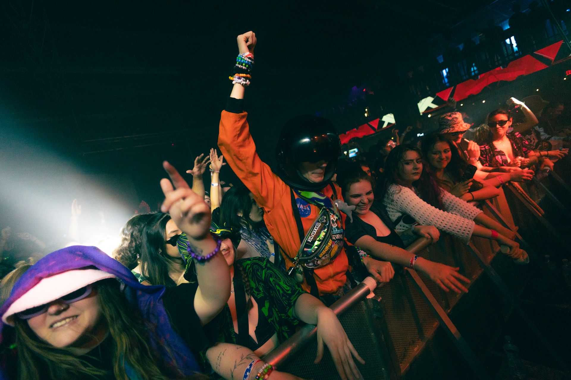 A crowd of people are standing in front of a stage at a concert.