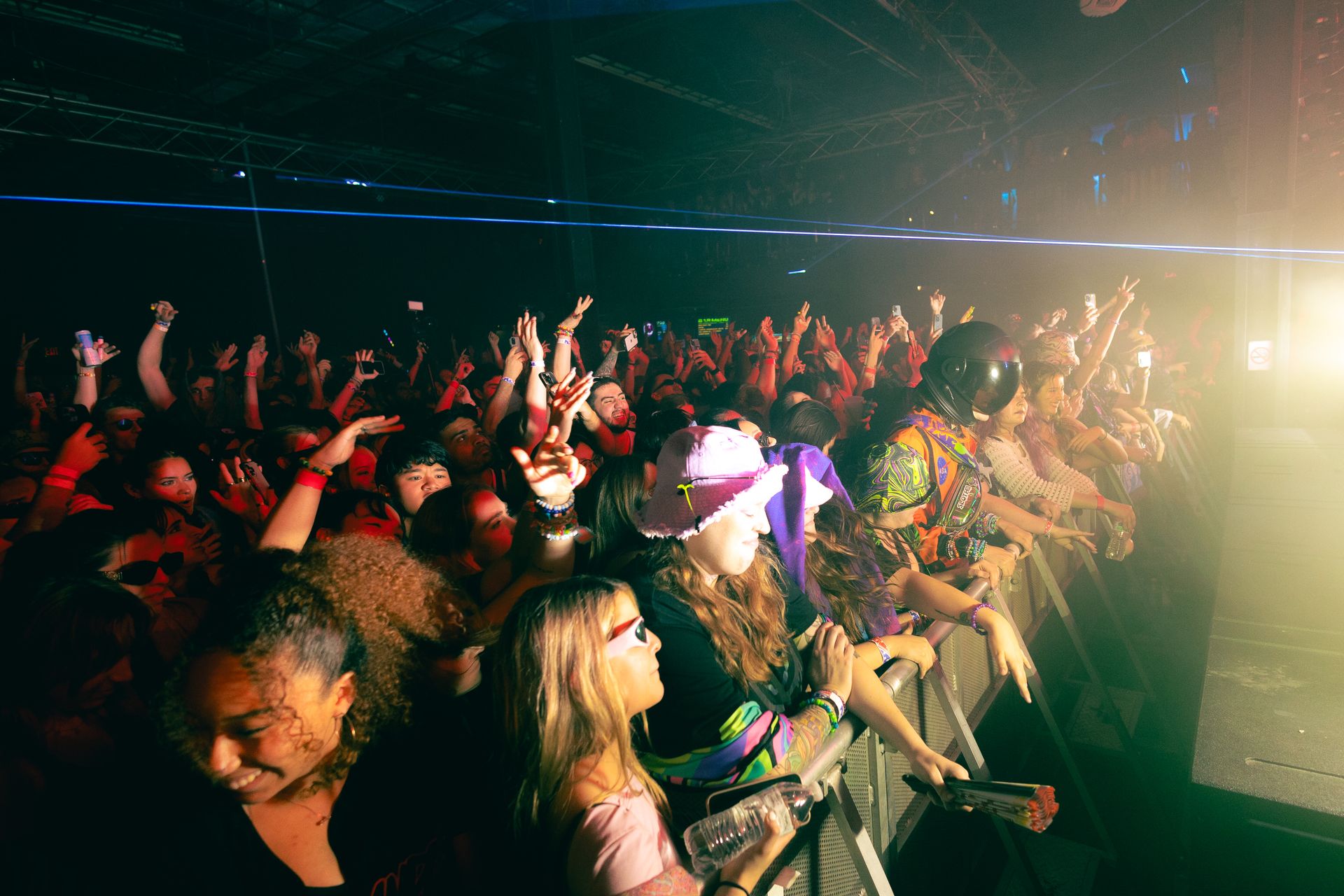 A crowd of people are standing in front of a stage at a concert.