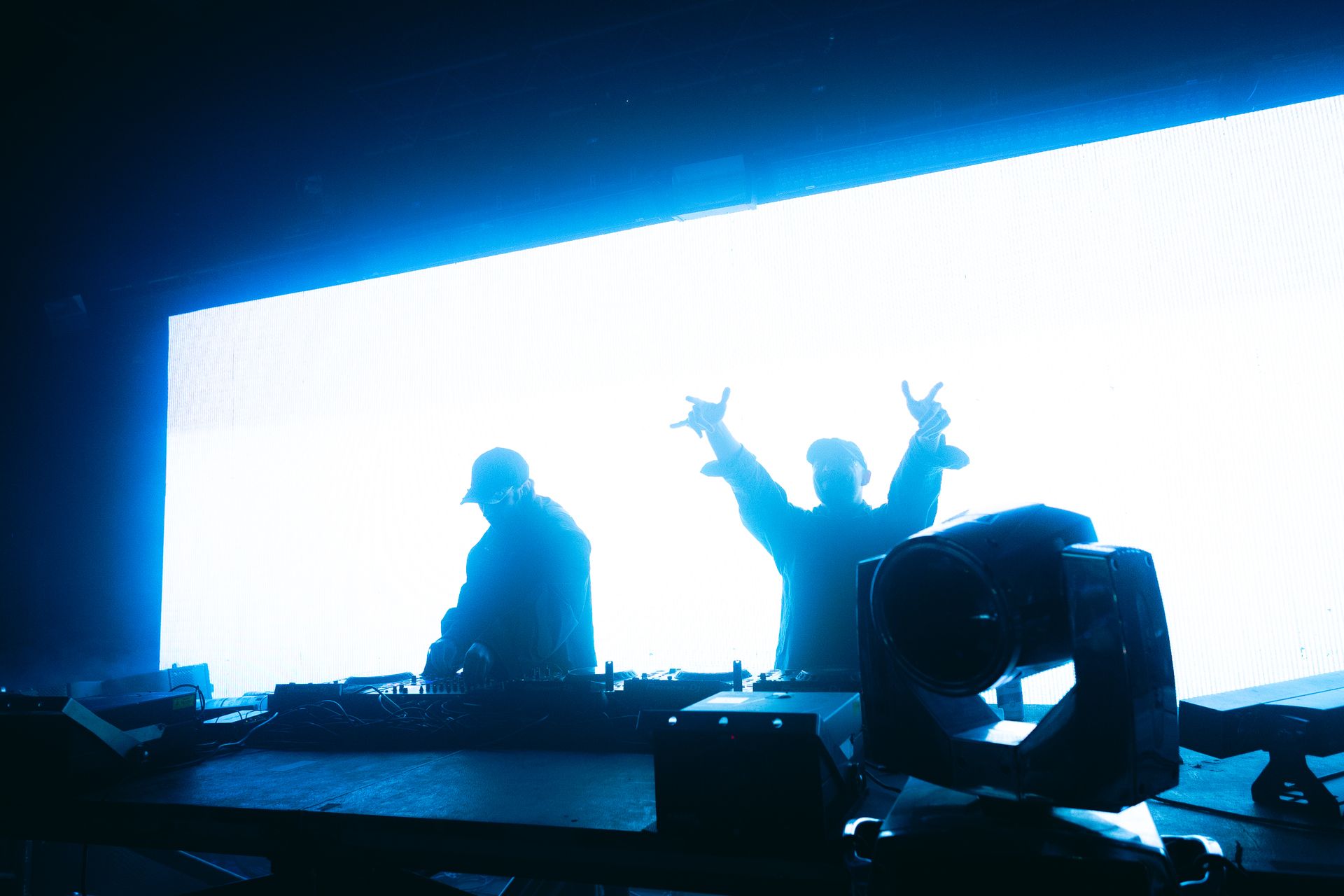 A couple of people standing in front of a large screen with their arms in the air