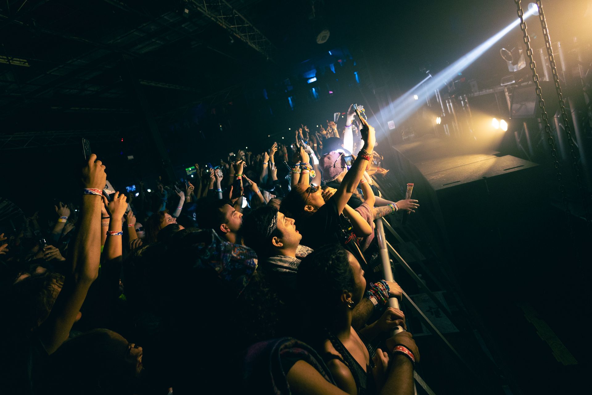 A crowd of people are watching a concert in a dark room.