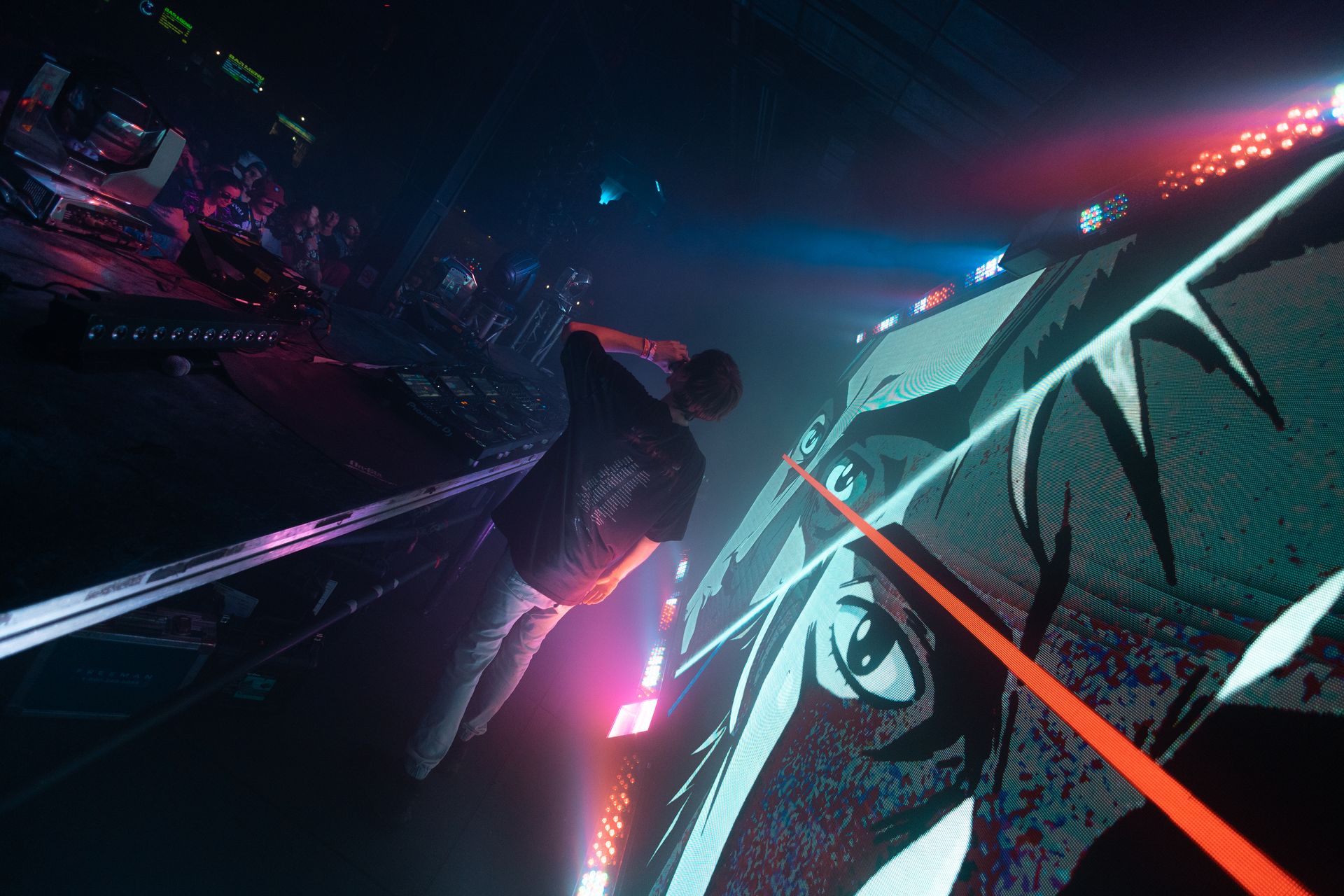 A man is standing in front of a large screen in a dark room.