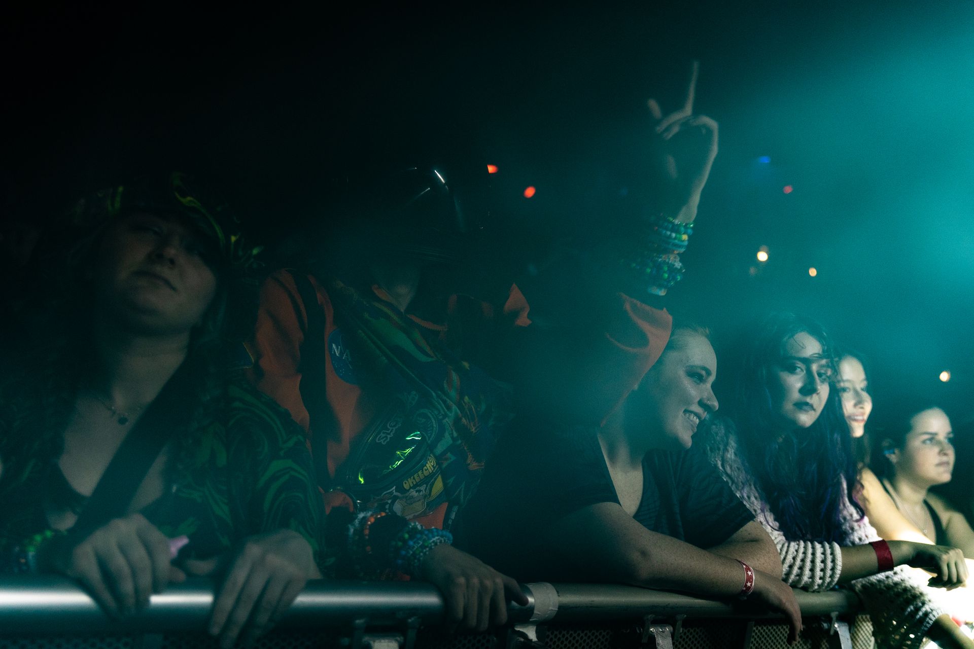 A group of people are sitting in a dark room watching a concert.