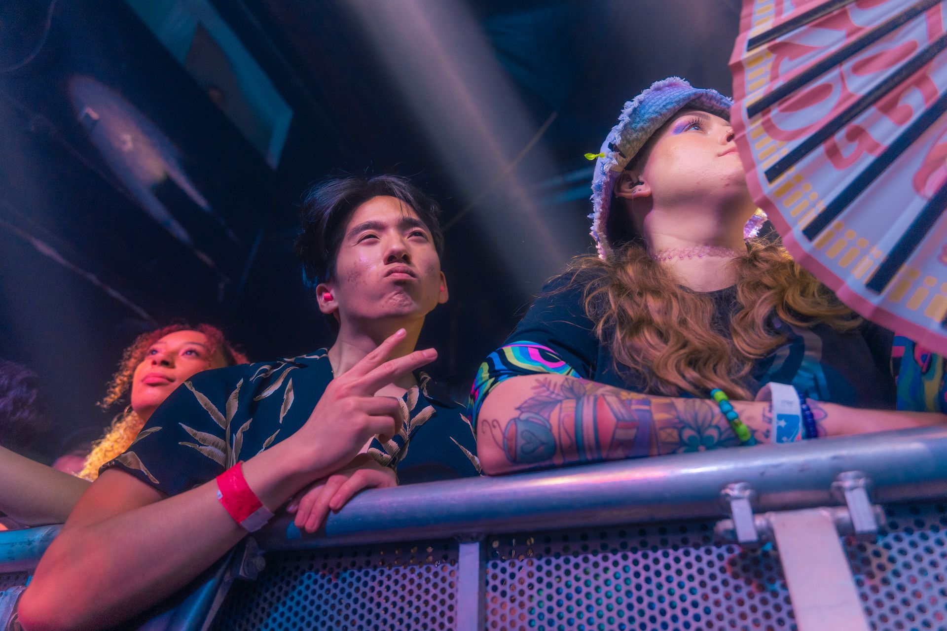 A group of people are sitting in a fence at a concert.