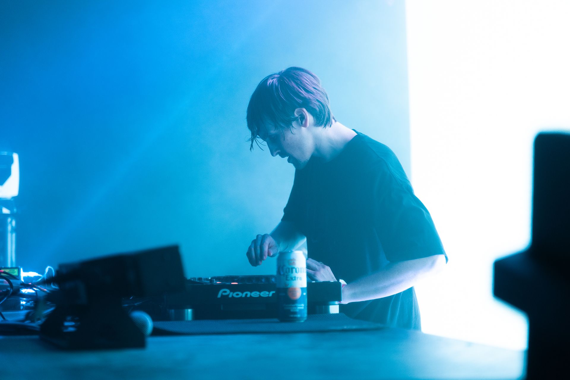 A man is playing a pioneer dj controller on a stage.