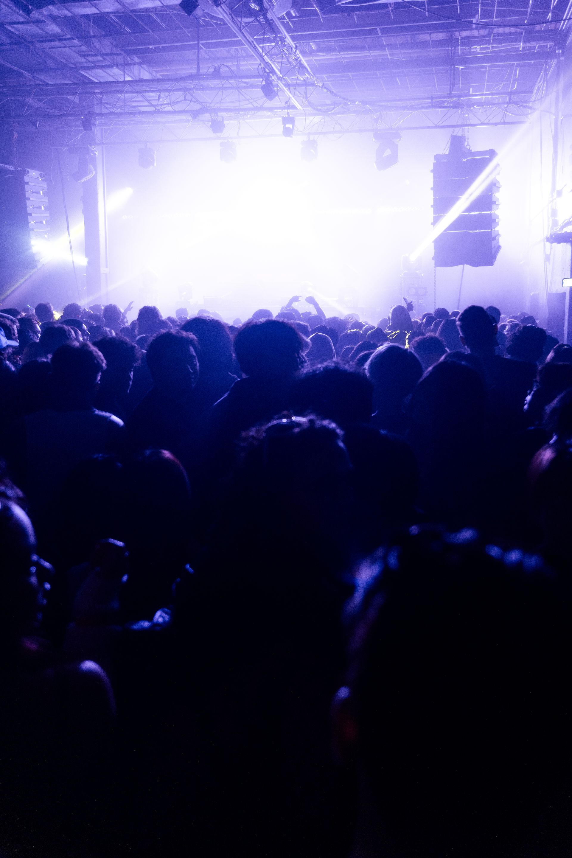 A crowd of people are standing in front of a stage at a concert.