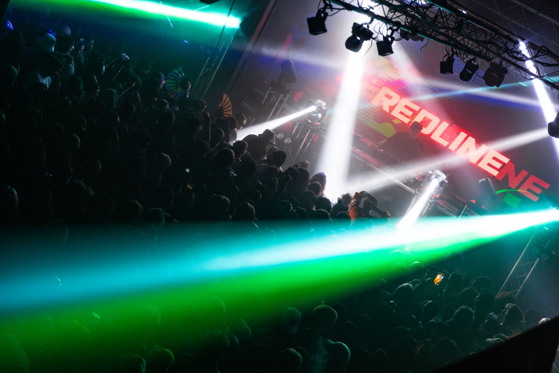 A crowd of people are sitting in front of a stage at a concert.
