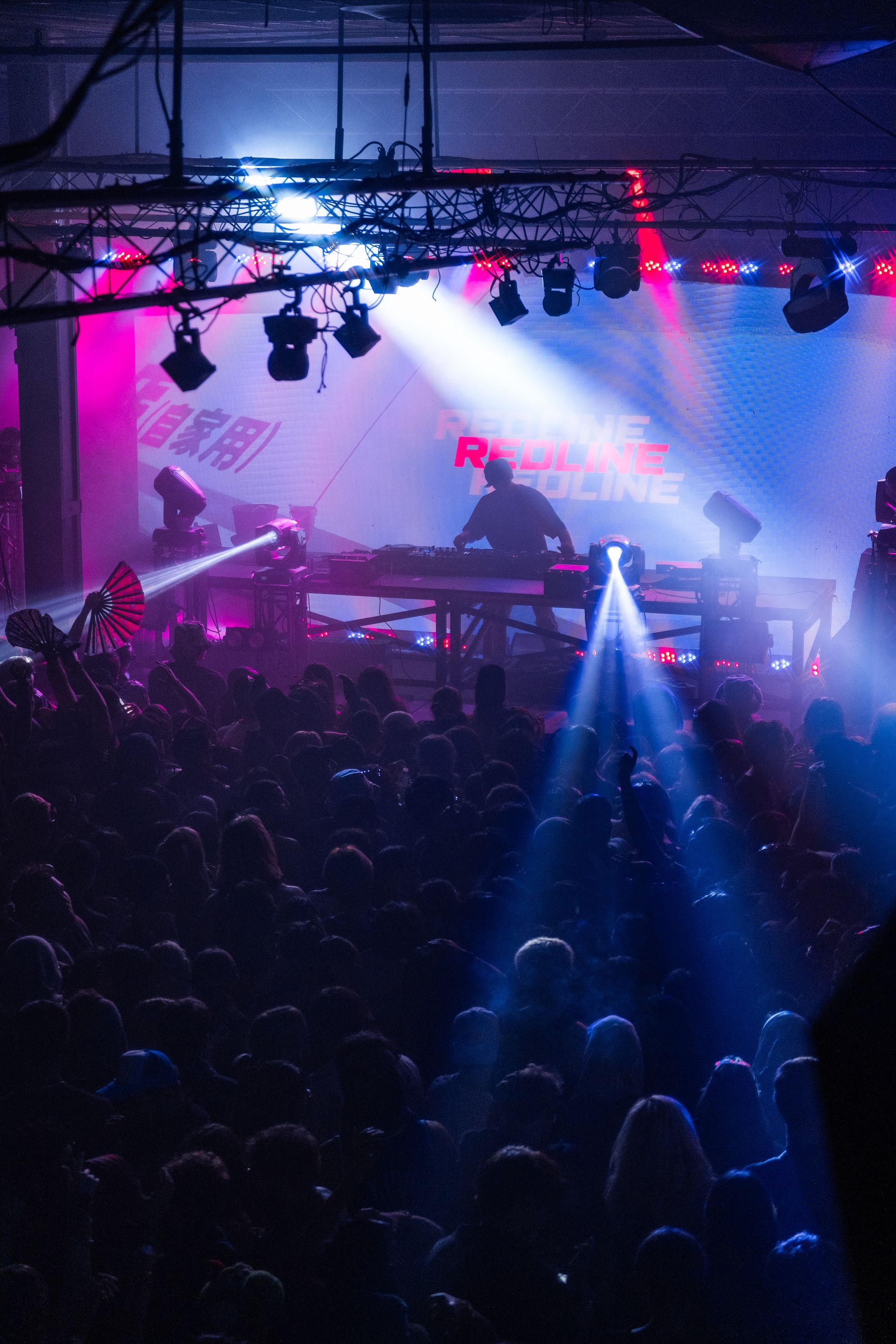 A crowd of people are standing in front of a stage at a concert.