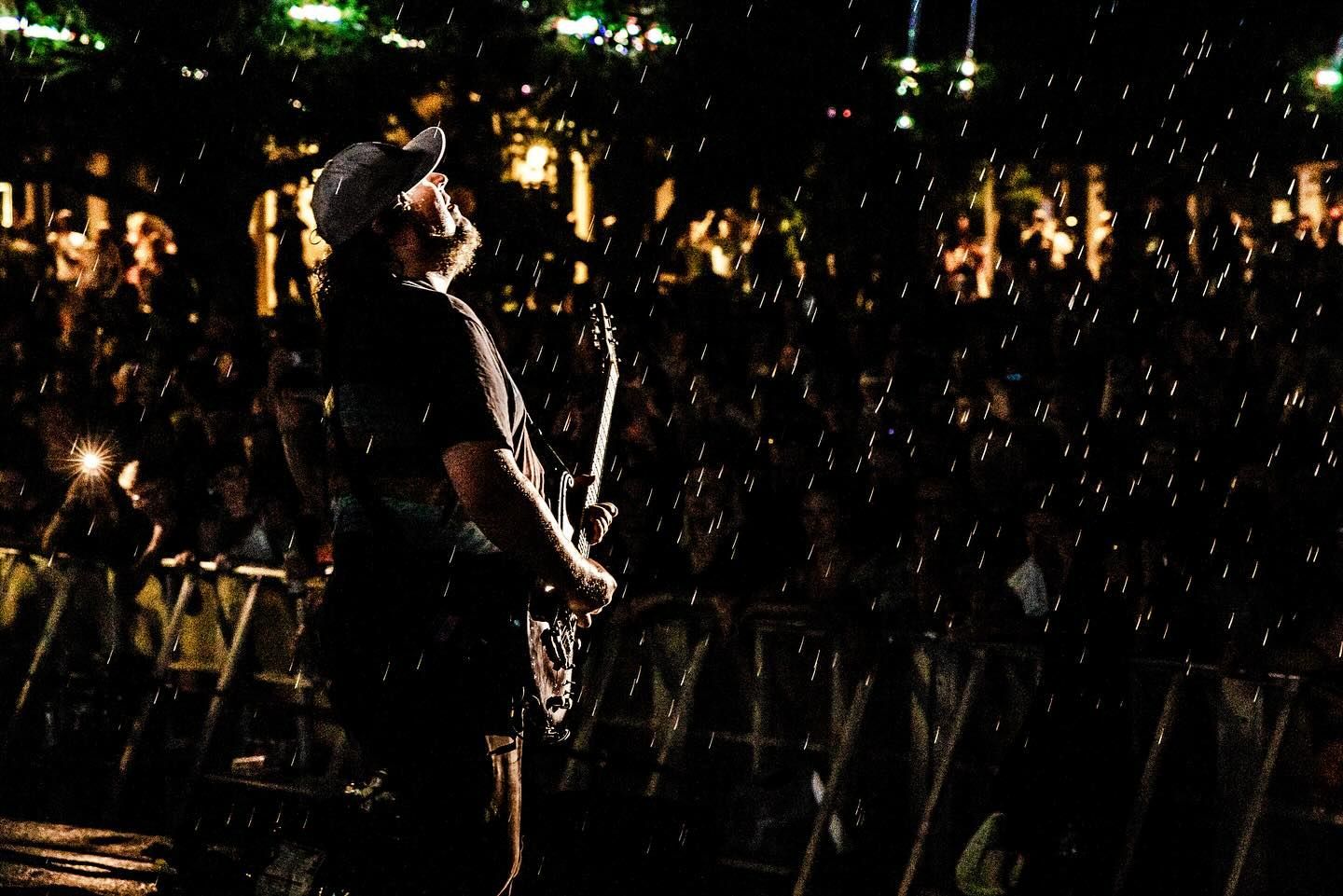 A man is playing a guitar in front of a crowd at a concert.