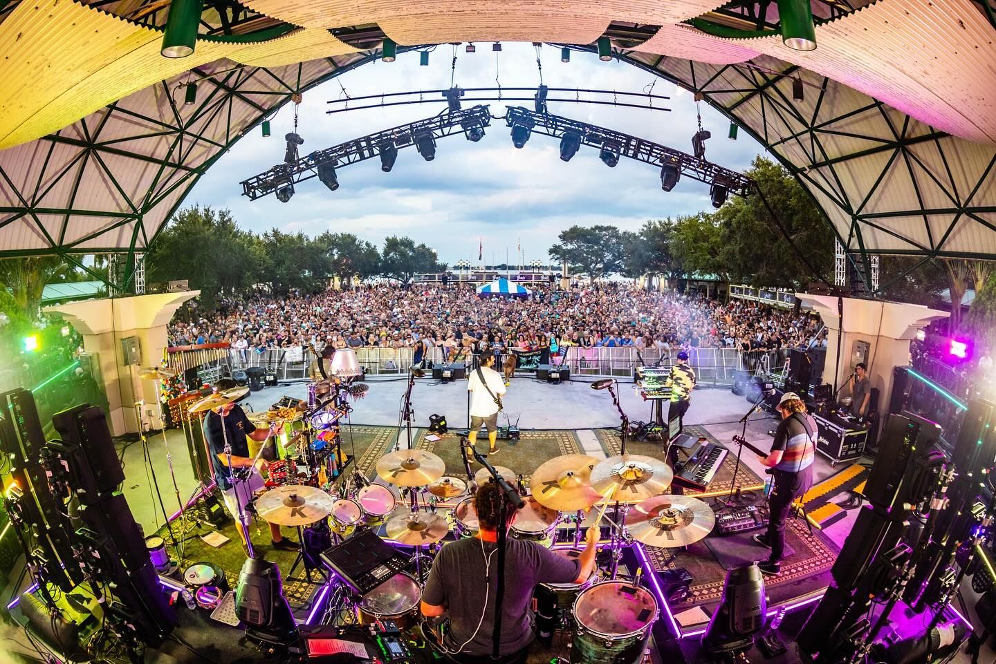 A group of people are playing drums on a stage in front of a crowd.