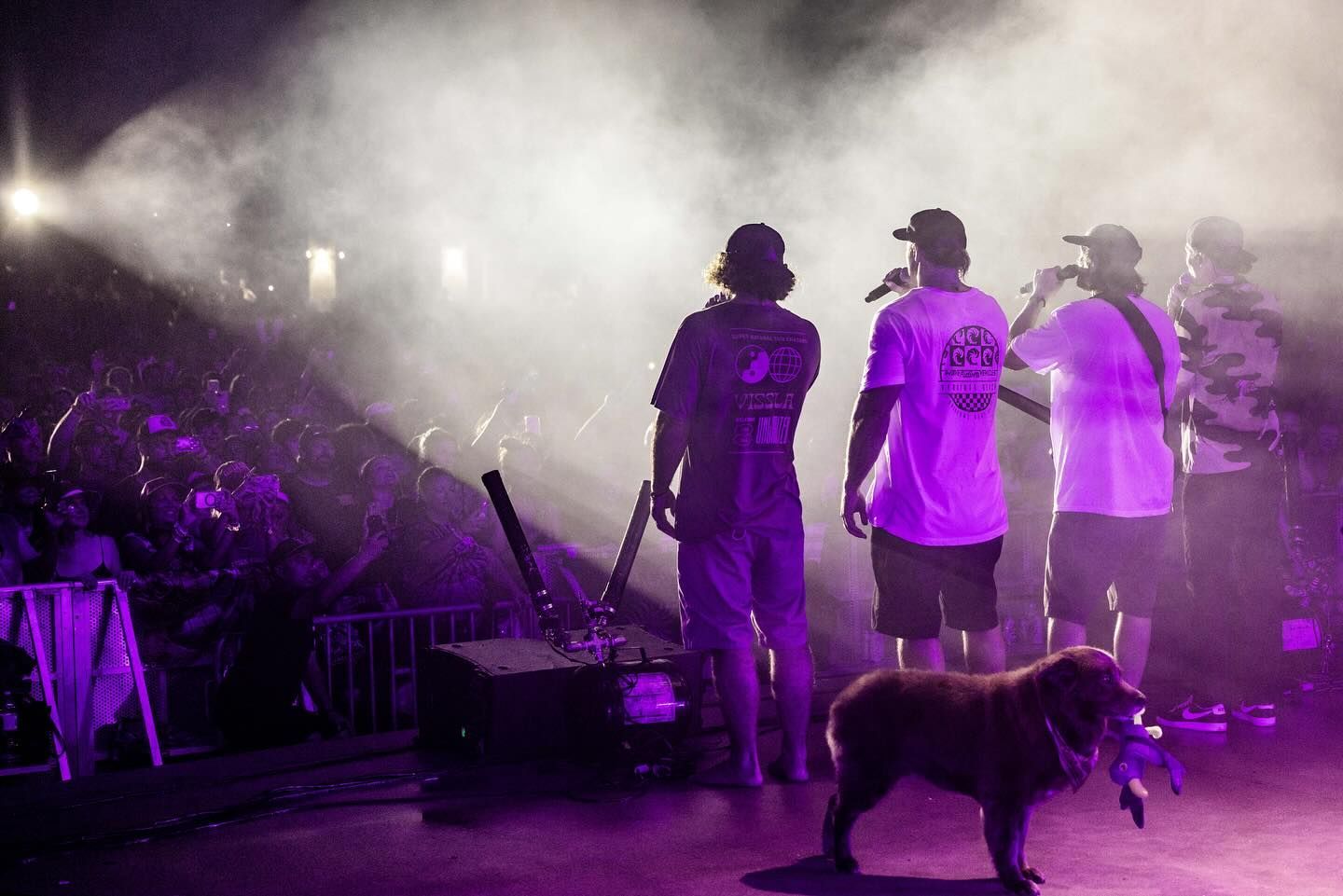 A group of people standing on a stage with a dog.