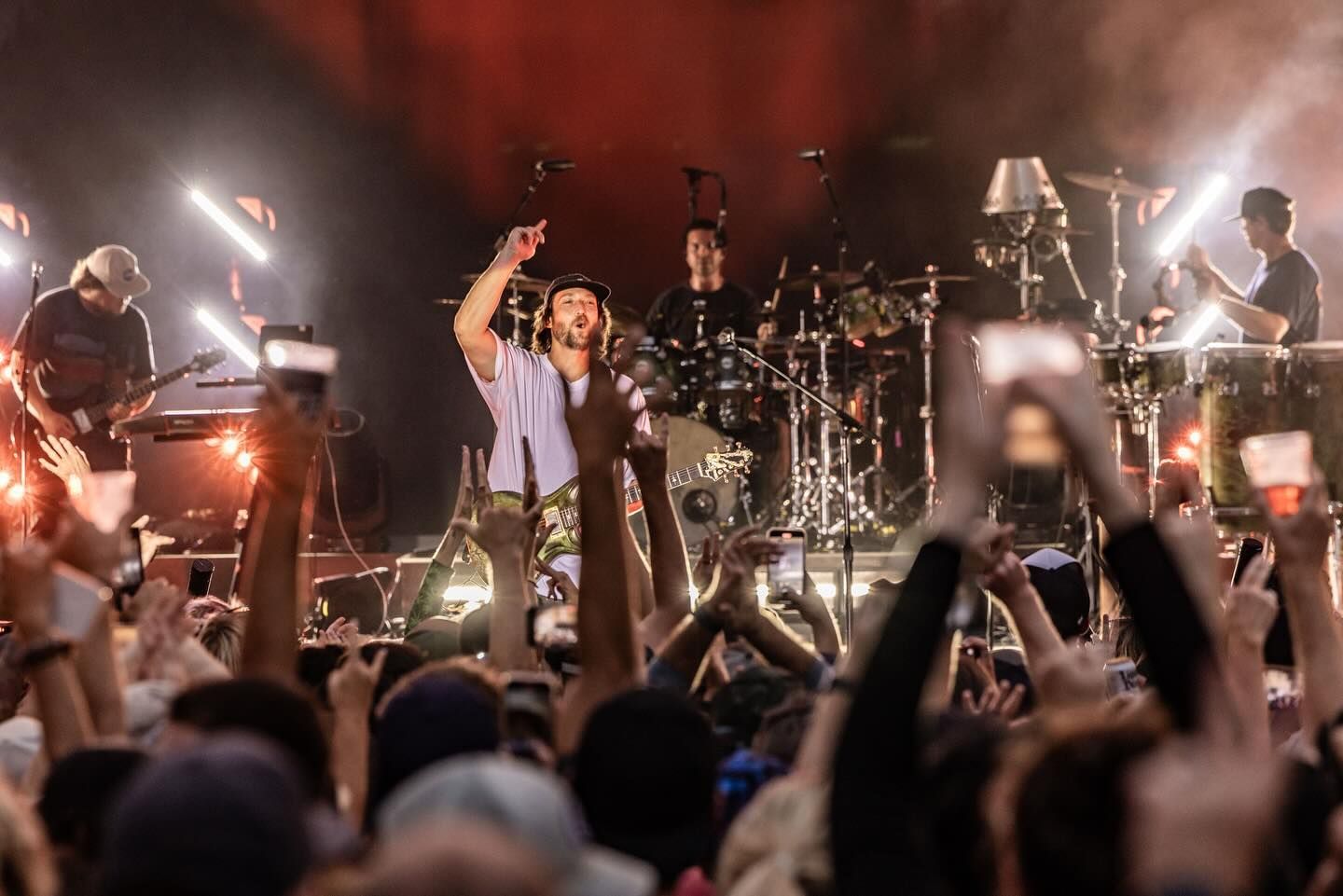 A group of people are standing in front of a crowd at a concert.