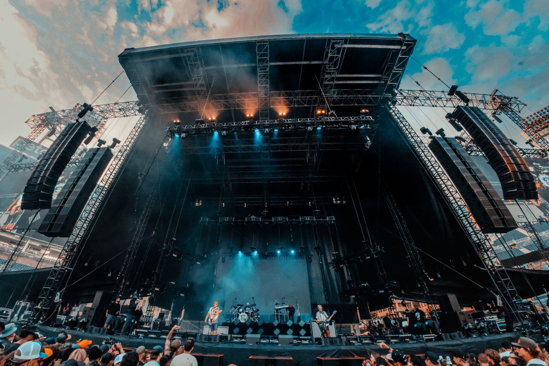 A group of people are standing in front of a large stage at a concert.