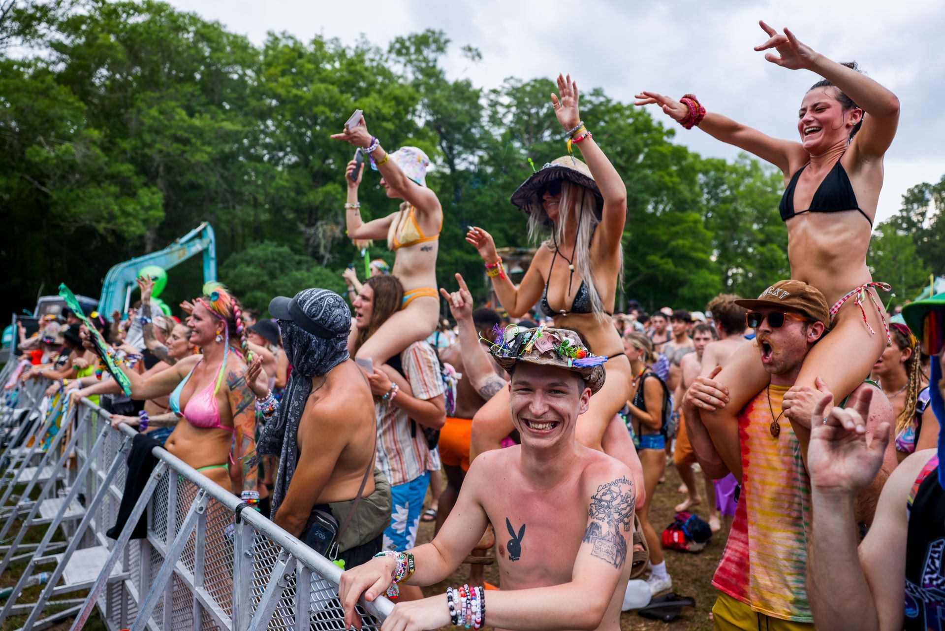 A man is carrying a woman on his shoulders at a music festival.