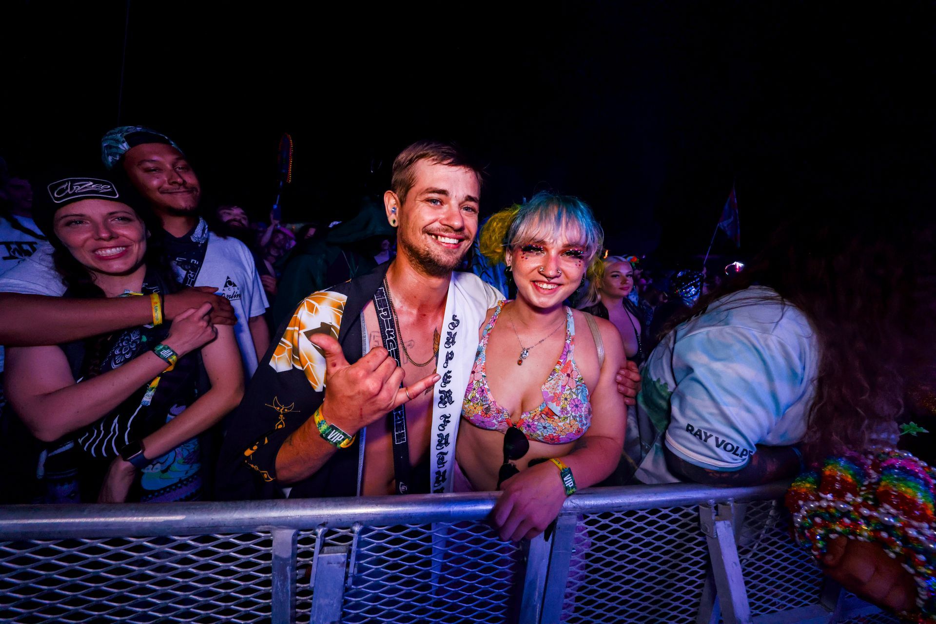 A man and a woman are posing for a picture at a concert.