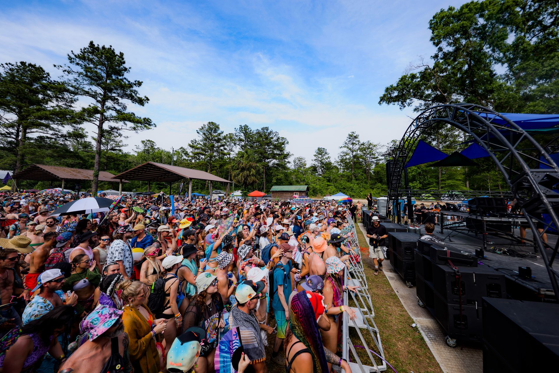 A large crowd of people are standing in front of a stage at a concert.