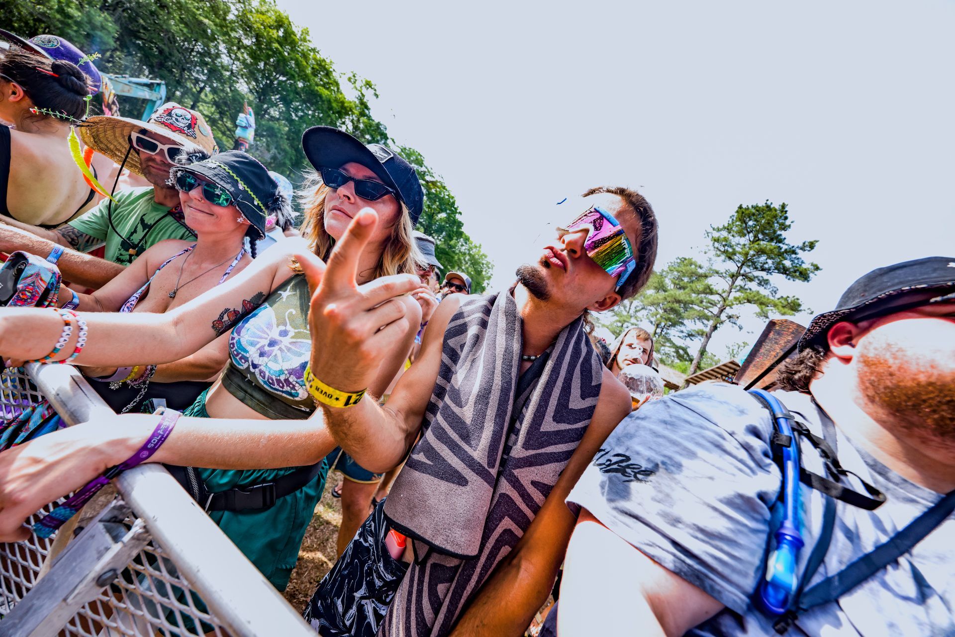 A group of people are standing around a fence at a festival.