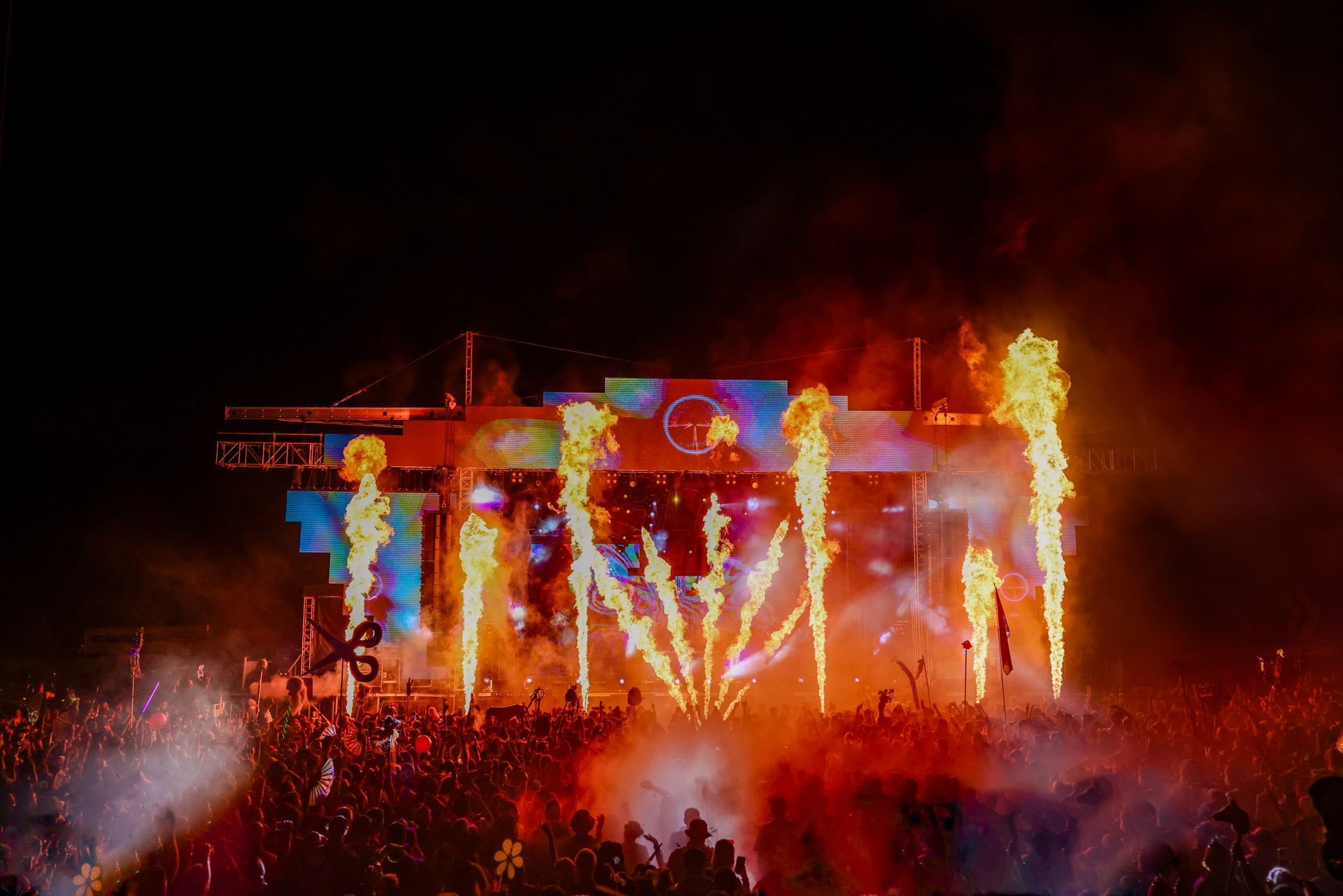 A crowd of people are watching fireworks at a concert.