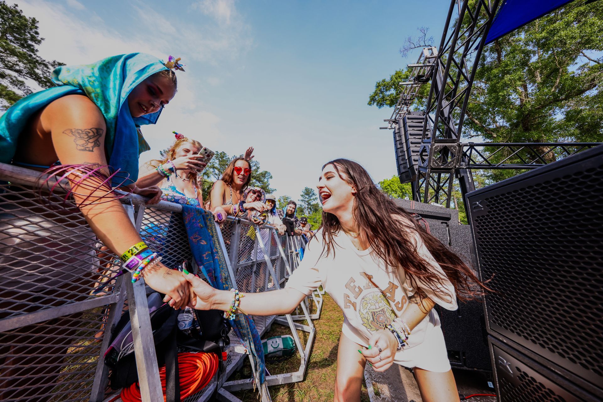A woman is shaking hands with a man at a music festival.