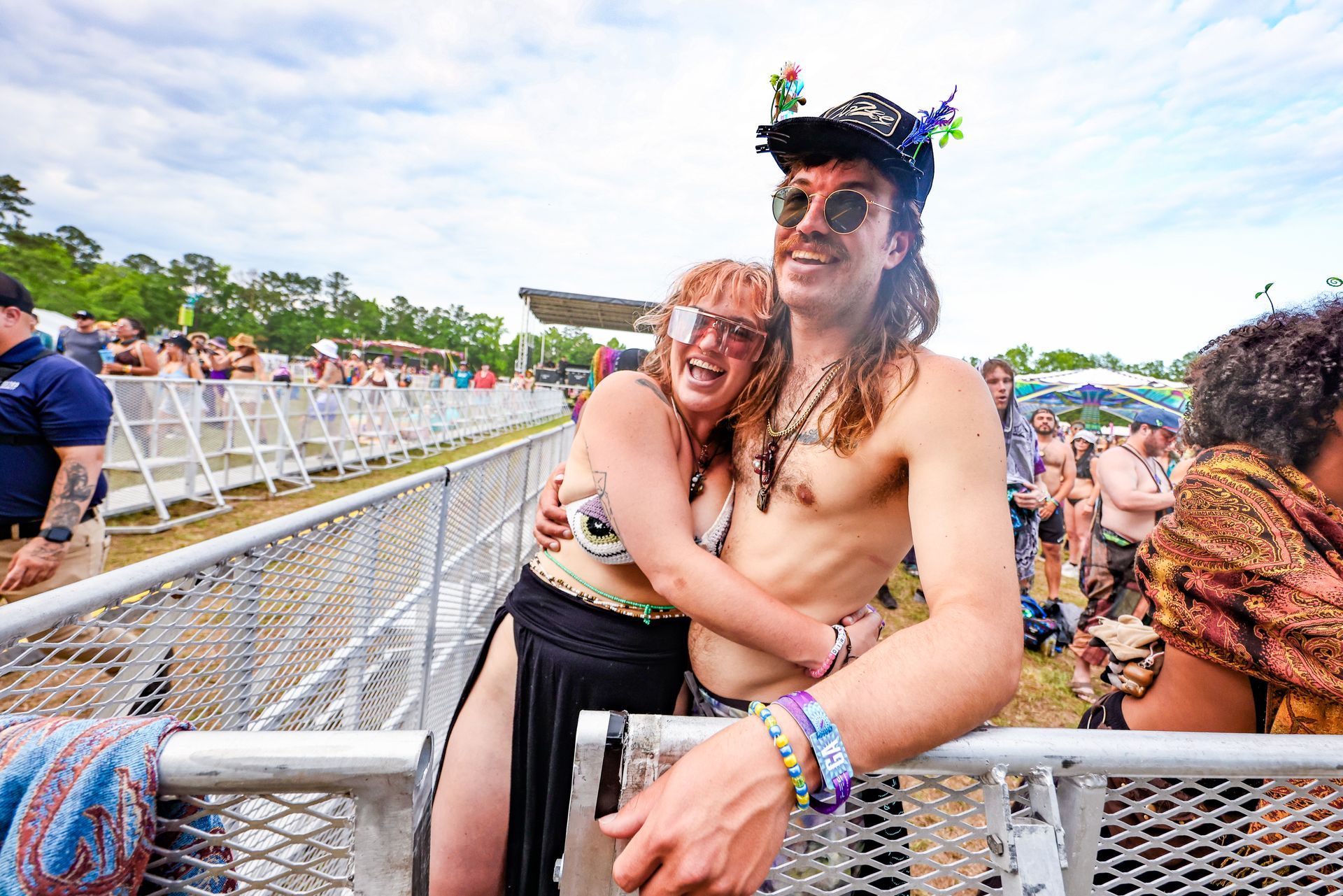 A man and a woman are hugging each other at a music festival.