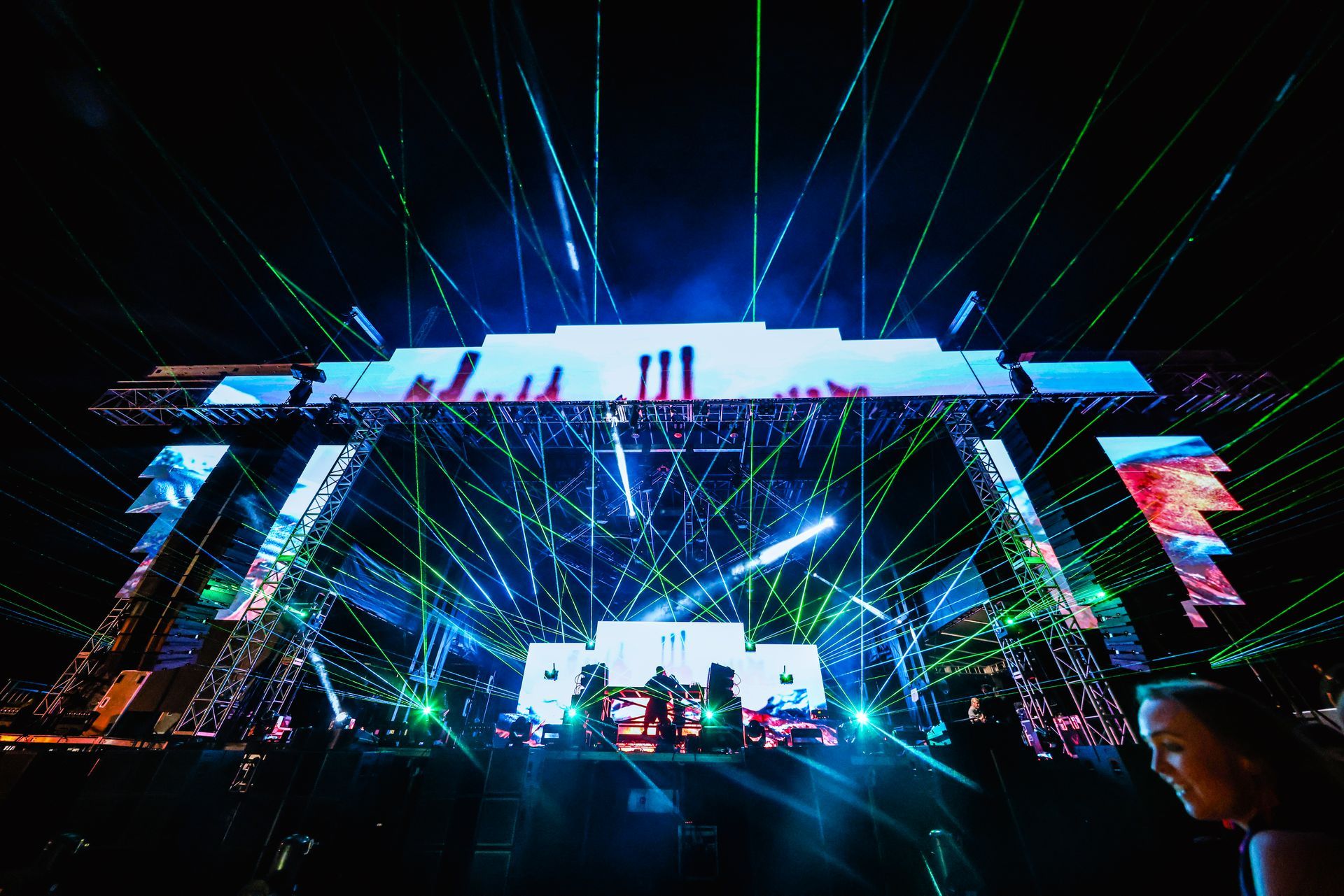 A woman is standing in front of a stage with a lot of lights on it.